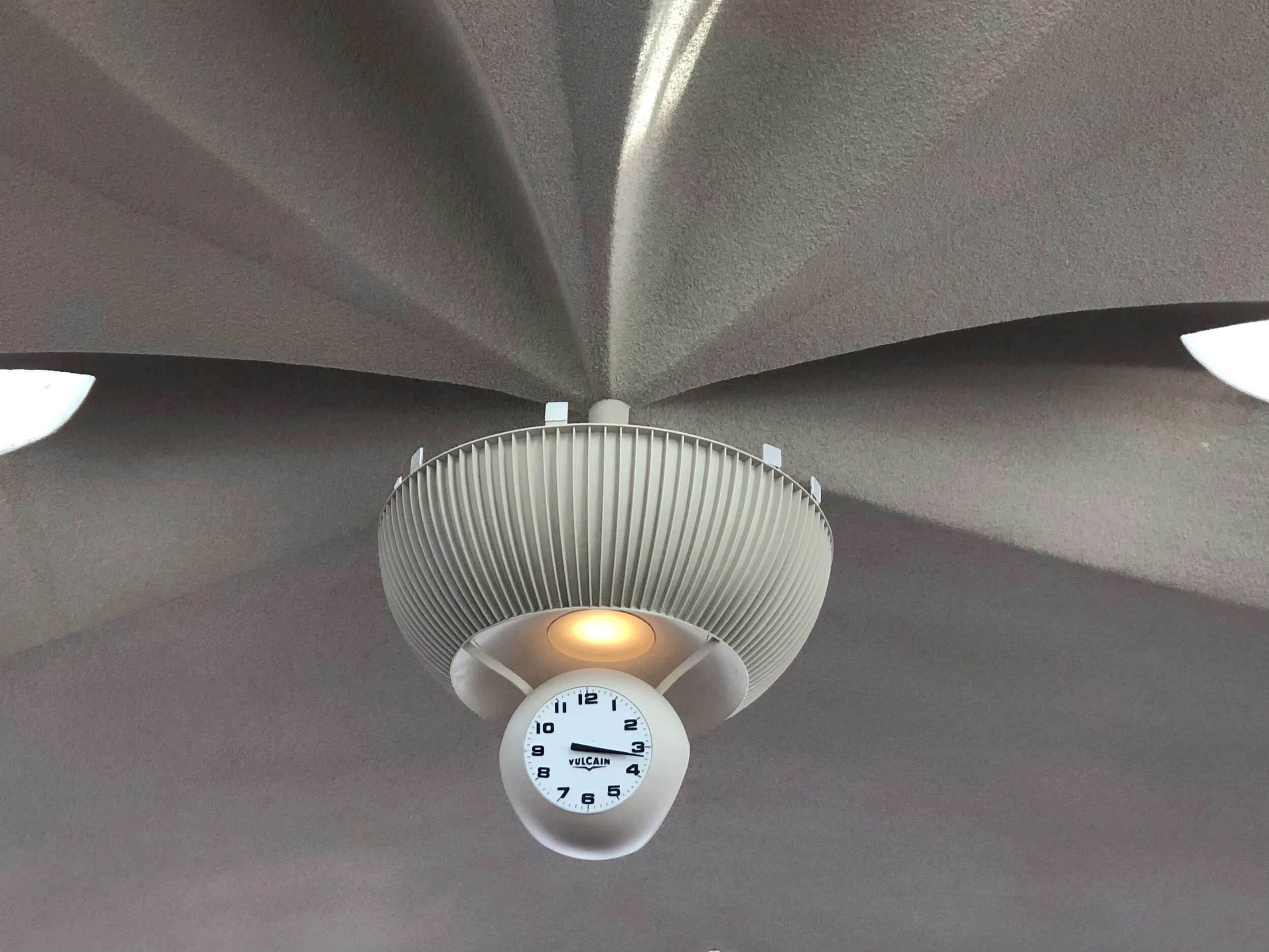 The original clock high above, positioned where the many arches converge on the ceiling