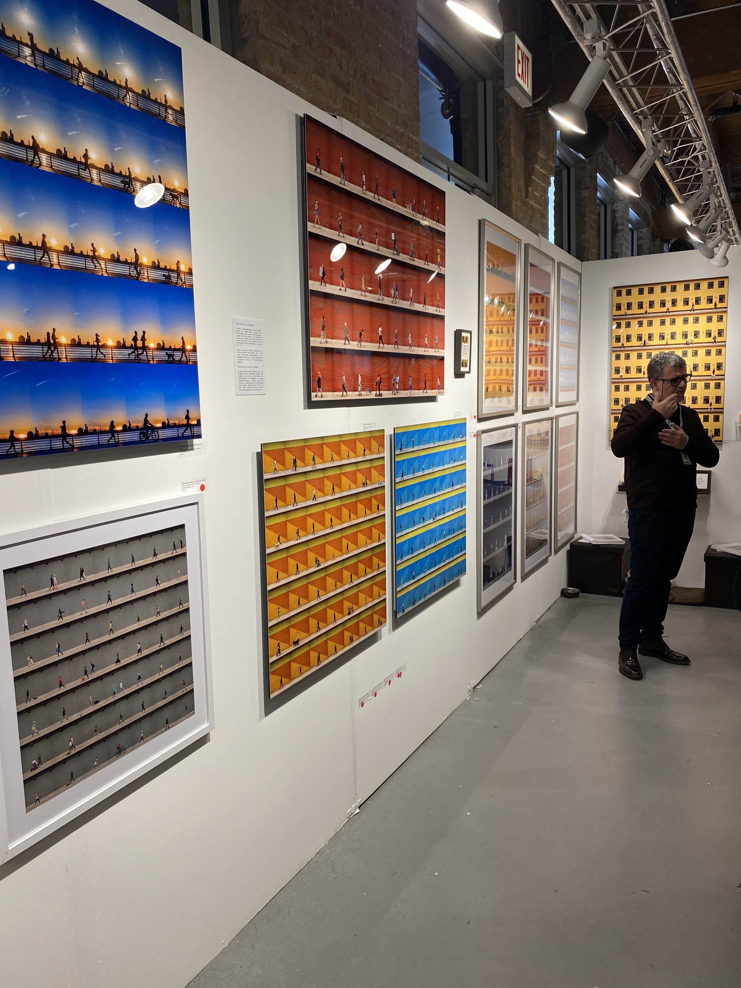 An artist stands by his photo collage works at the Other Art Fair in Chicago