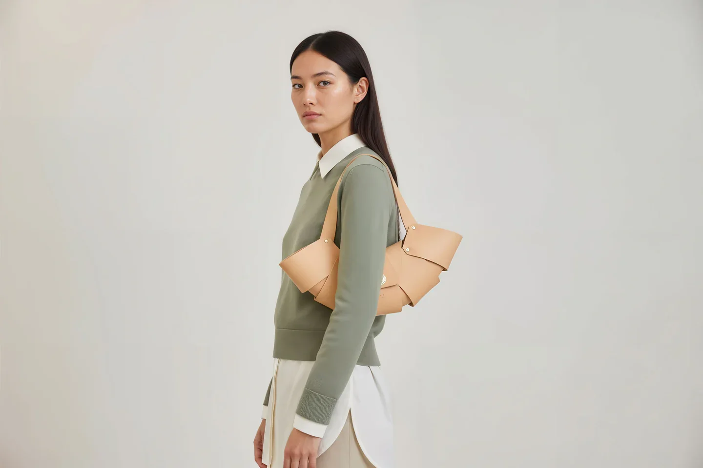 A woman with a tan leather croissant-shaped purse from Atelier Madre