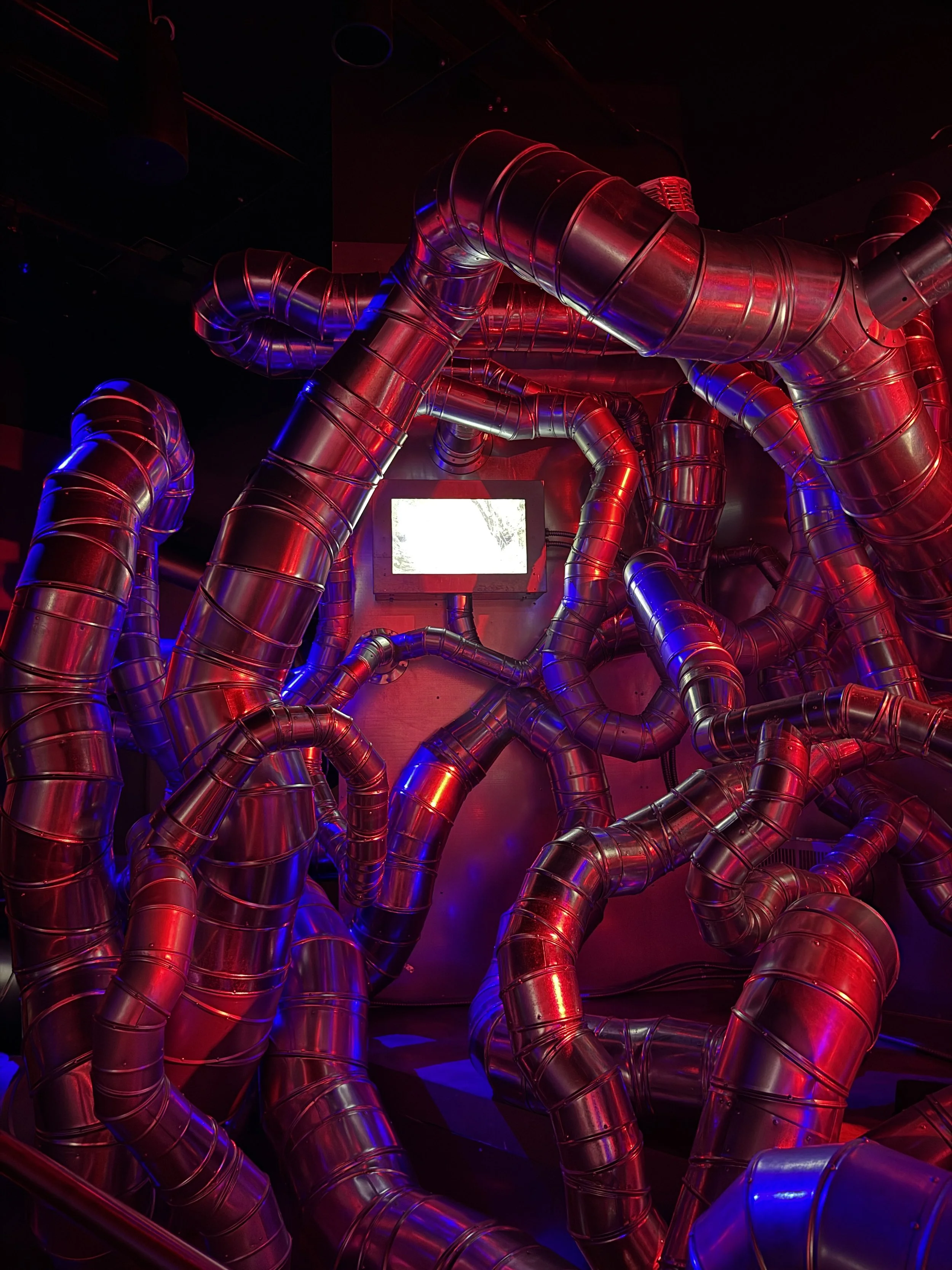 Ductwork snaking in every direction around a monitor at Meow Wolf Radio Tave in Houston, Texas