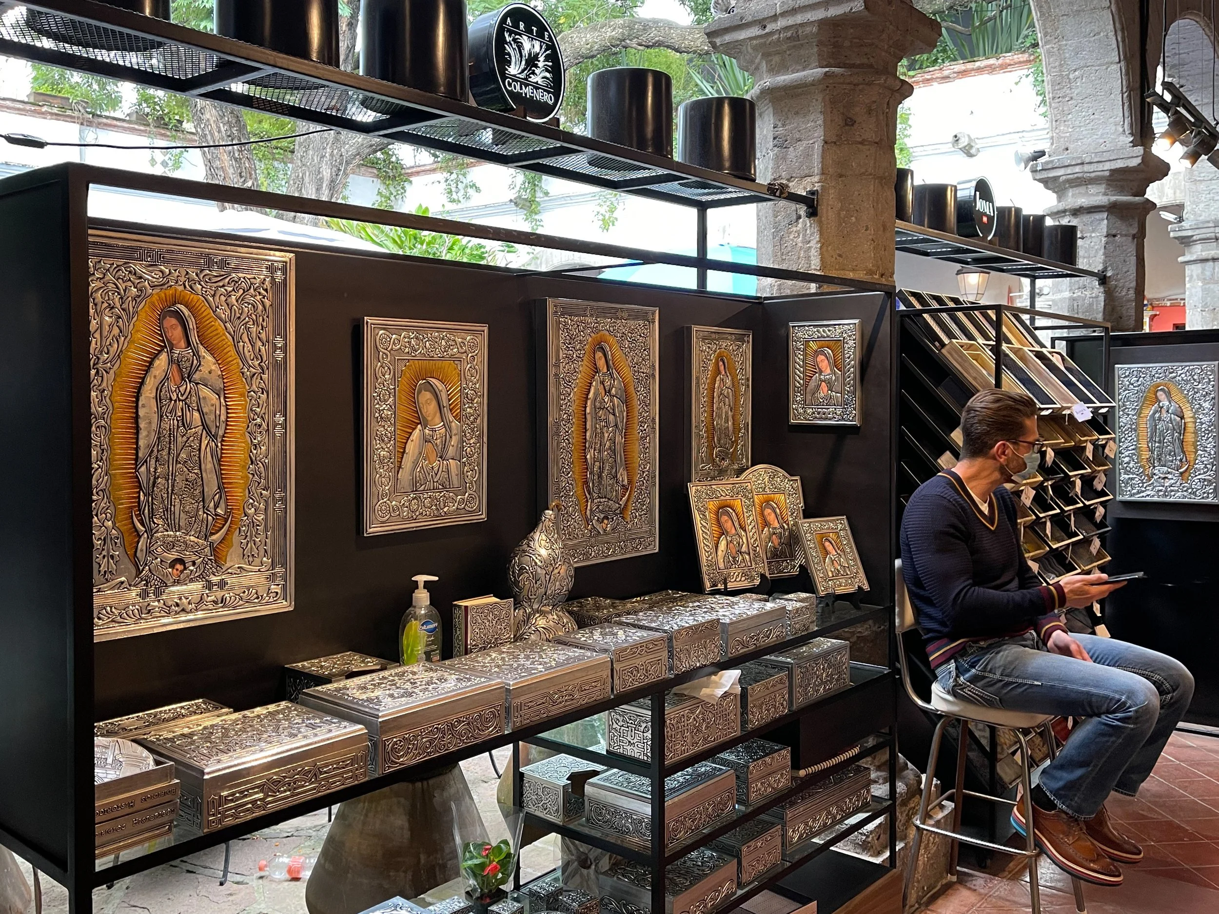 Man selling pressed tin artwork of the Virgin Mary at the Bazar Sábado