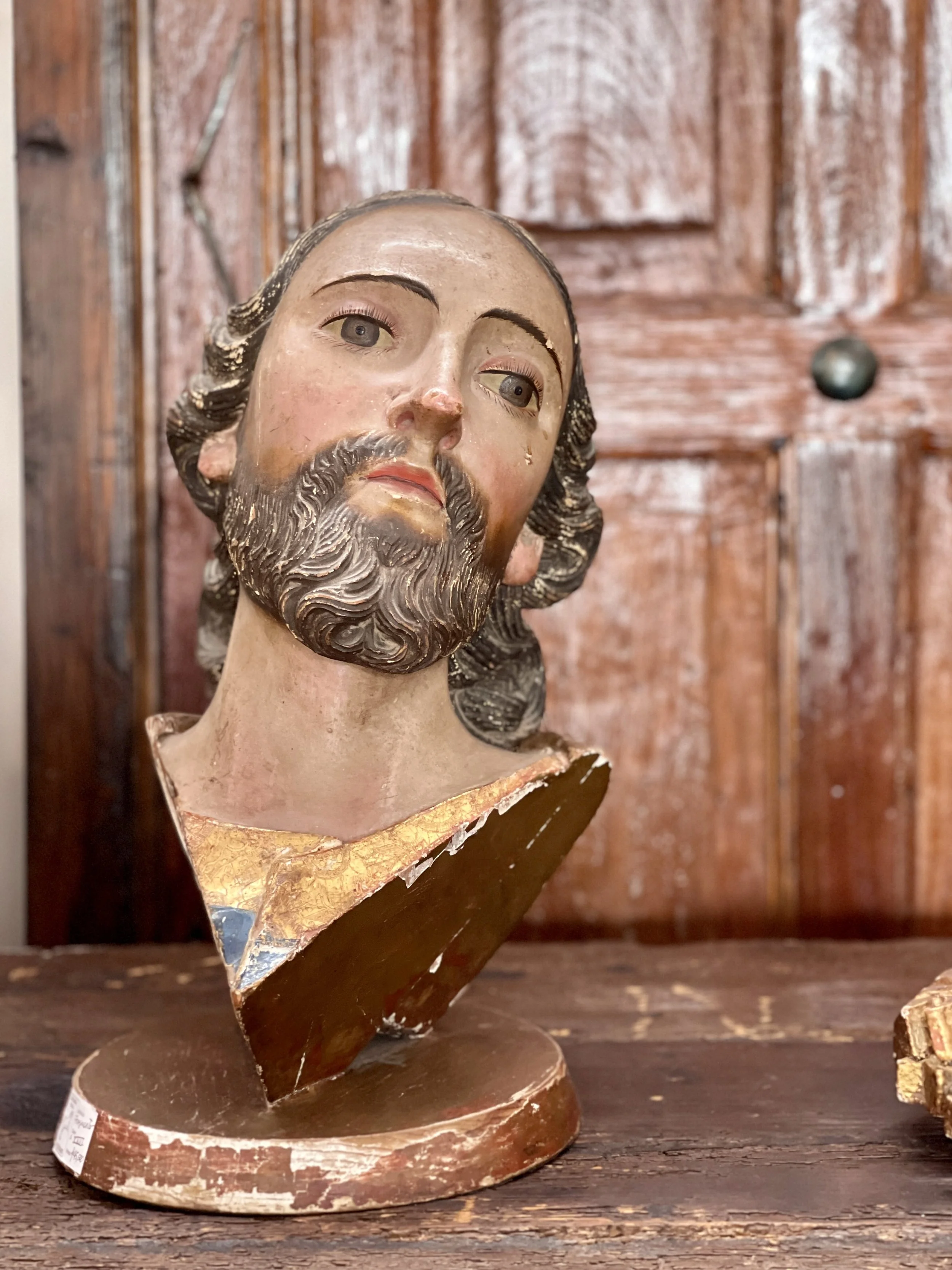 Painted head of Jesus by wood wall at antique store in Mexico