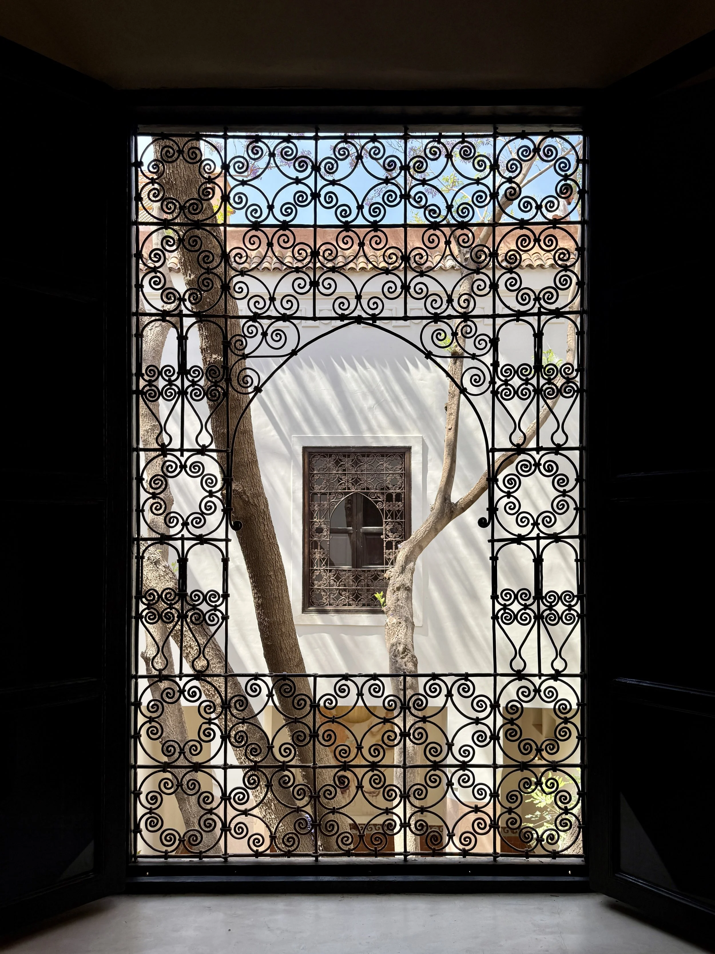 Curlicues cover a wrought iron grille over a window in a hotel room at Rosemary Riad in Marrakech