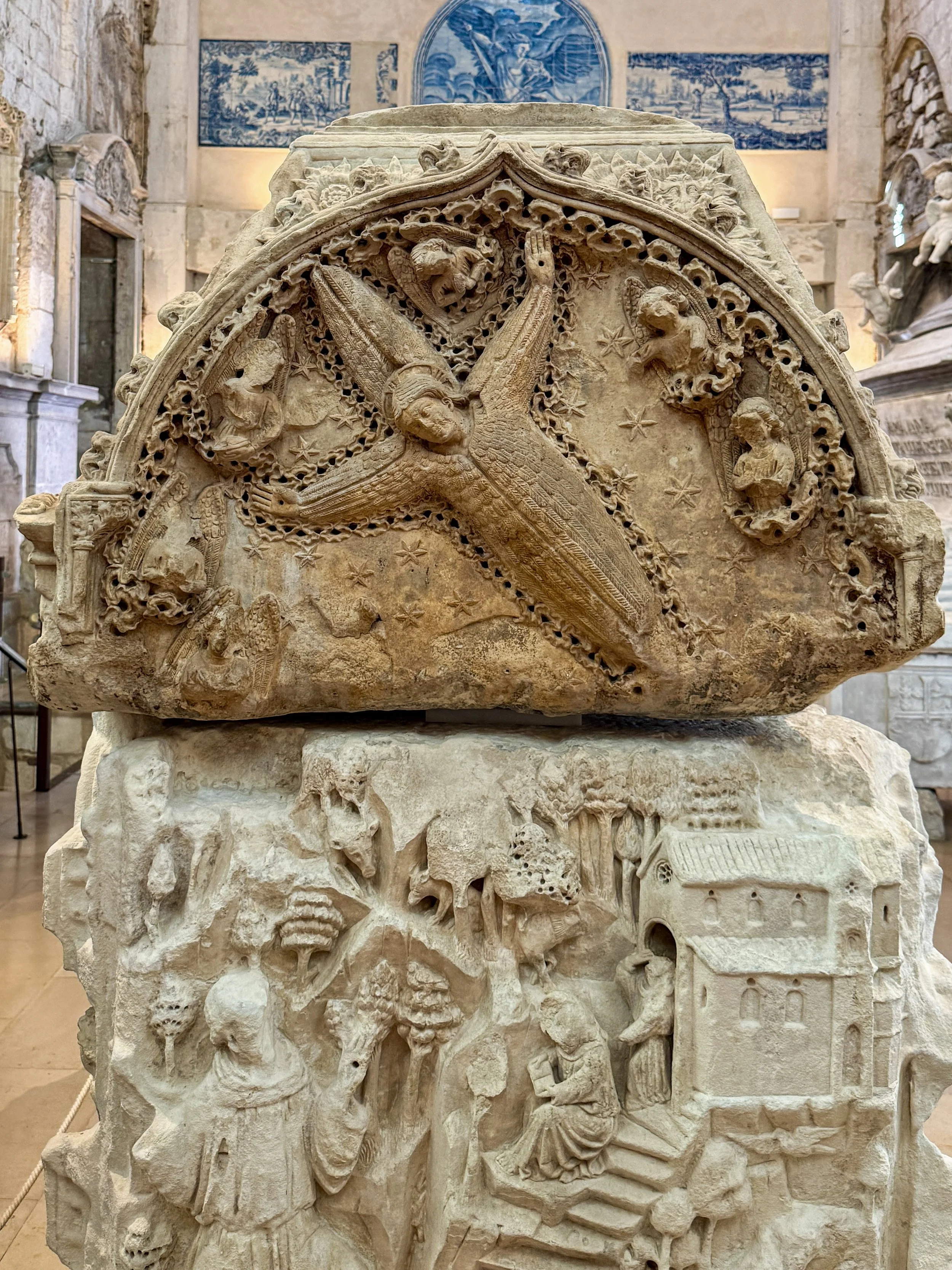 A winged figure soars through a star-filled sky atop the intricately carved 14th-century tomb of King Fernando I at the Carmo museum in Lisbon