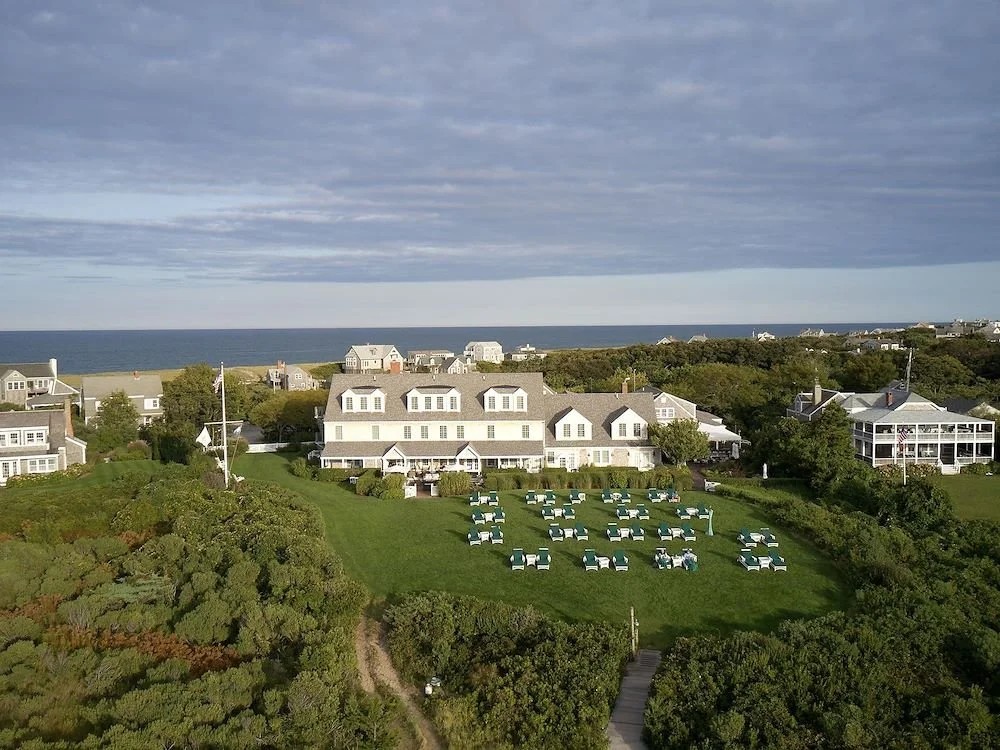 Aerial view of white Wauwinet Hotel in Nantucket with lawn chairs