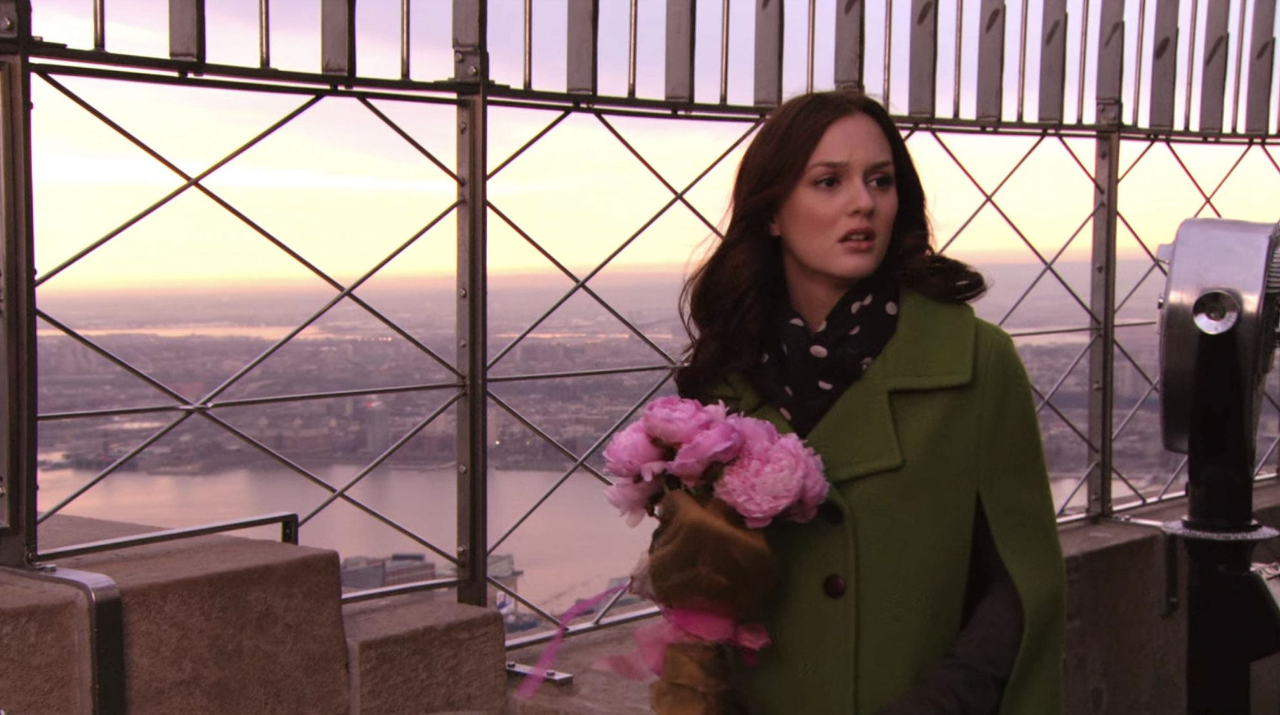 Blair in green coat holding pink flowers atop the Empire State Building on Gossip Girl