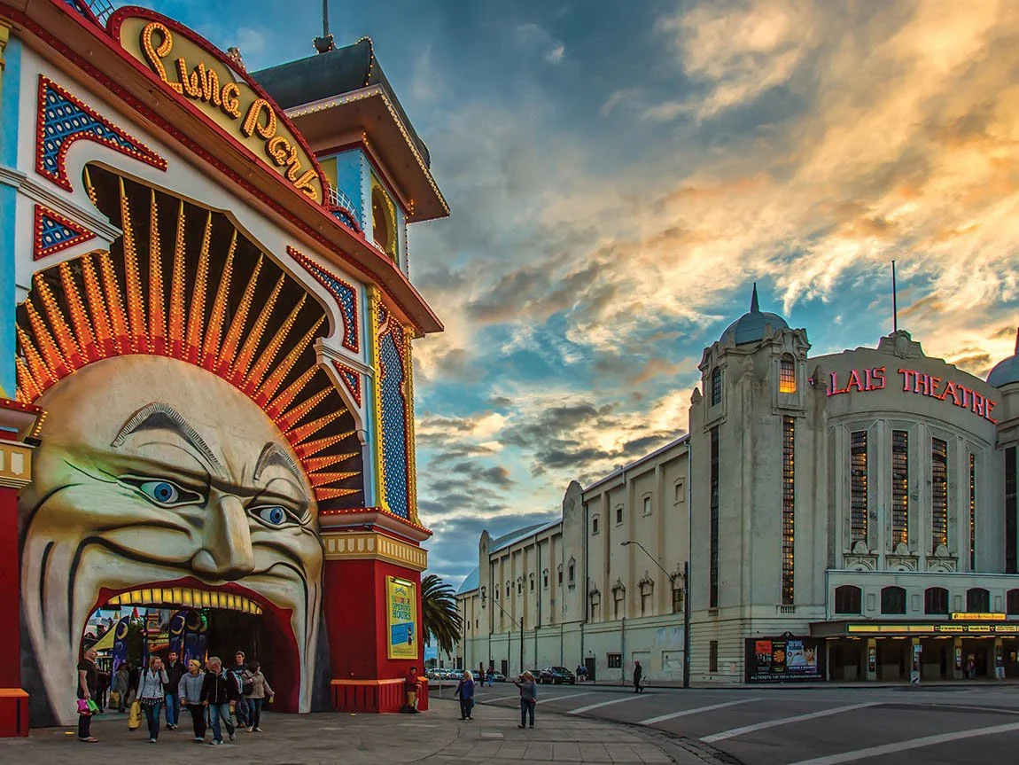 People exit through a giant mouth at Luna Park, next to a theater in St Kilda, Melbourne, Australia