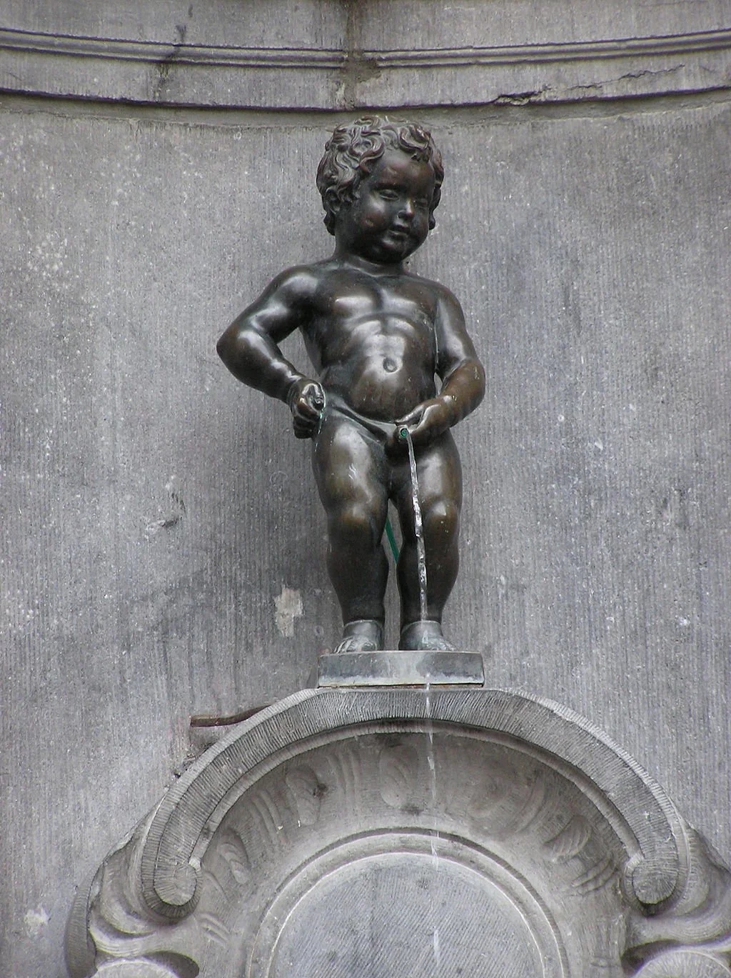Manneken Pis, the small statue of a naked boy peeing into a fountain in Brussels, Belgium