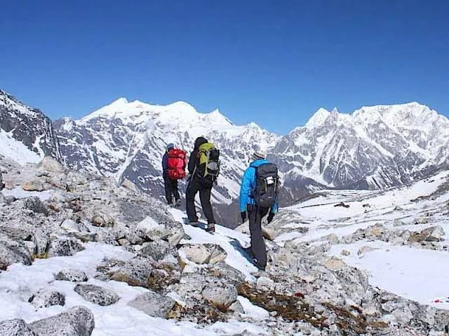 Three trekkers walk through the snowy mountains on the Manaslu Circuit trek in Nepal