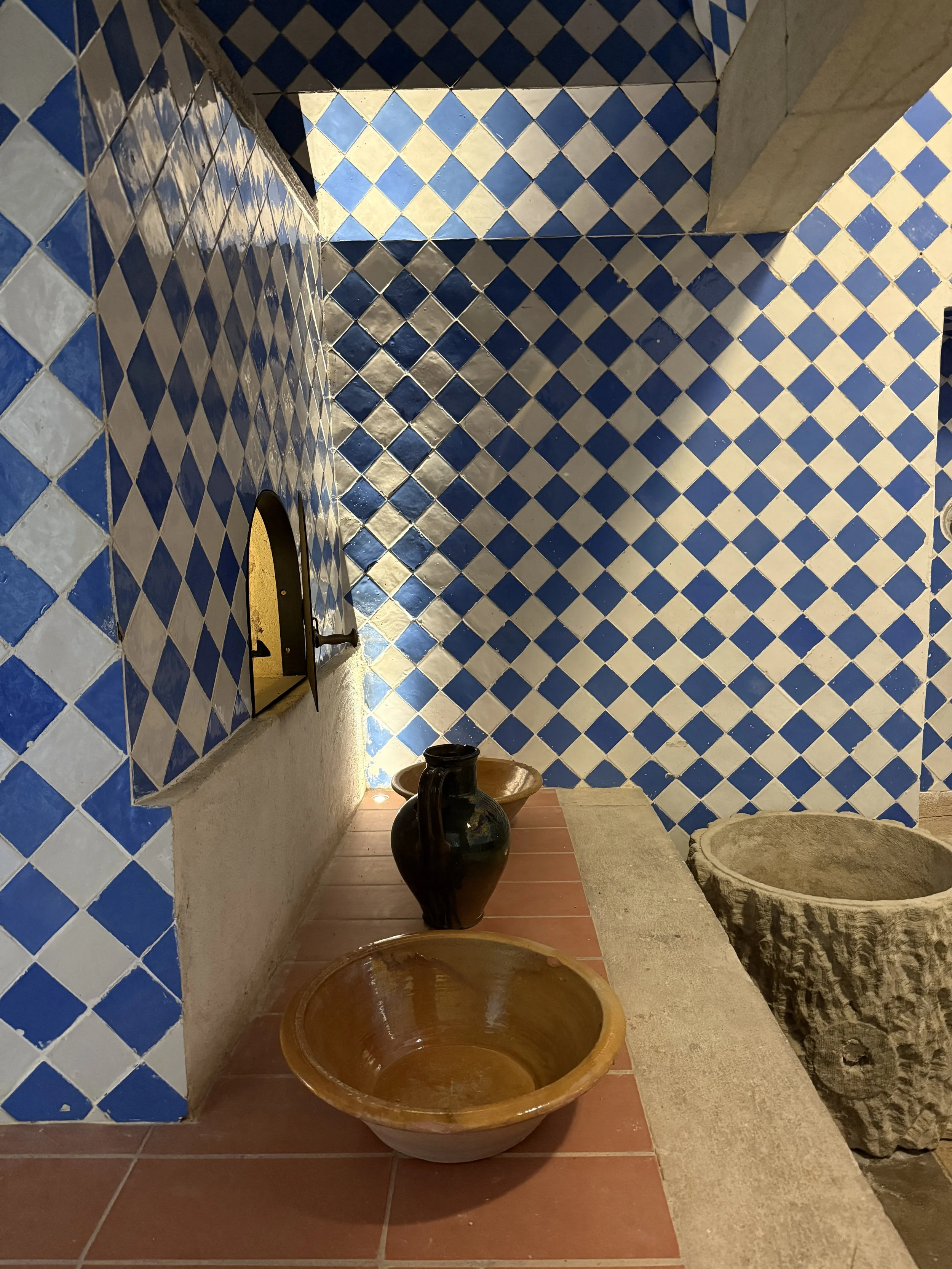 Blue and white checkered wall tiels, bowls, a vase and a cork container at the Chalet da Condessa d’Edla's kitchen