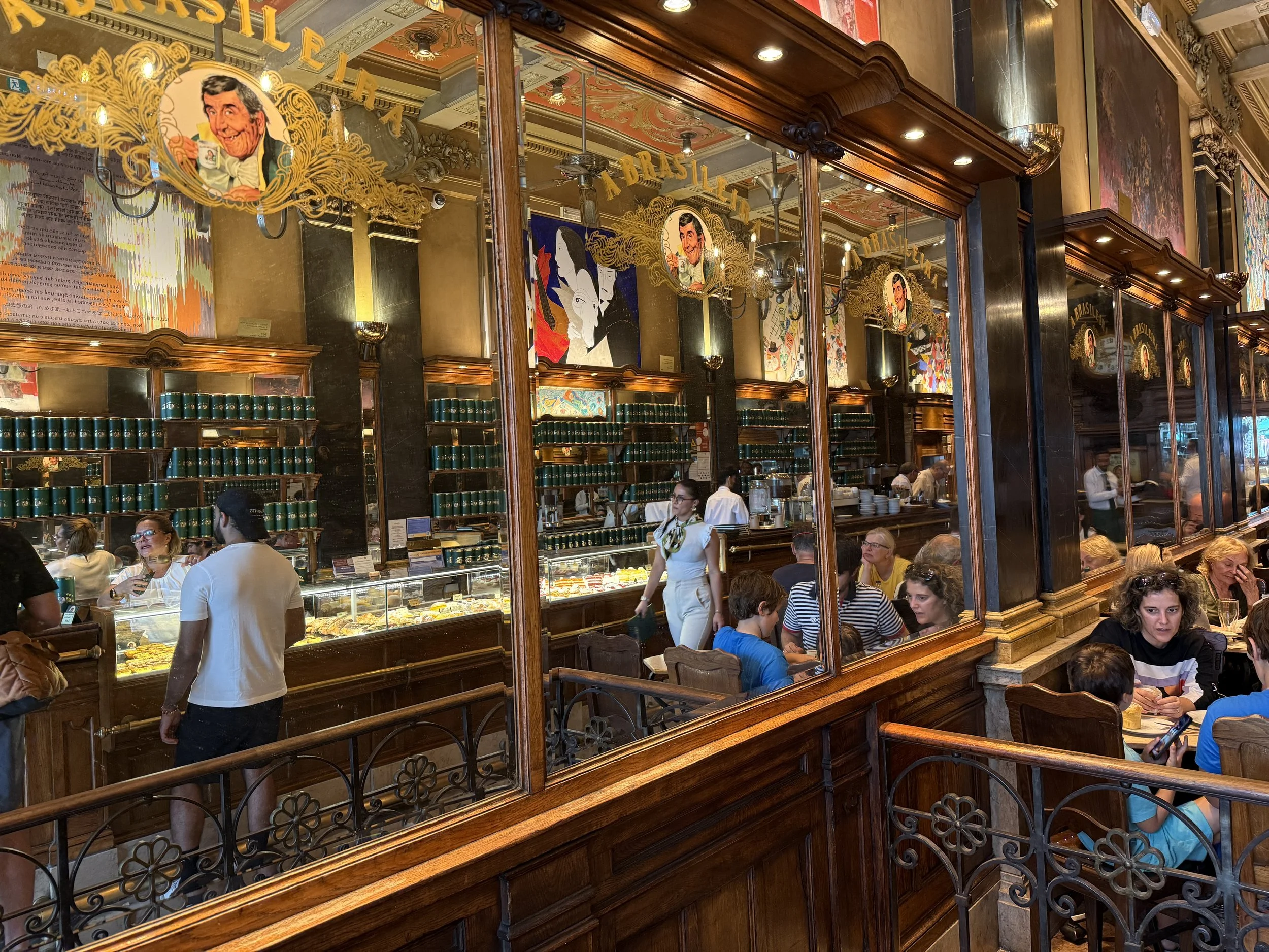 A mirrored wall showing the counter and tables at A Brasileira coffeeshop in Lisbon, Portugal