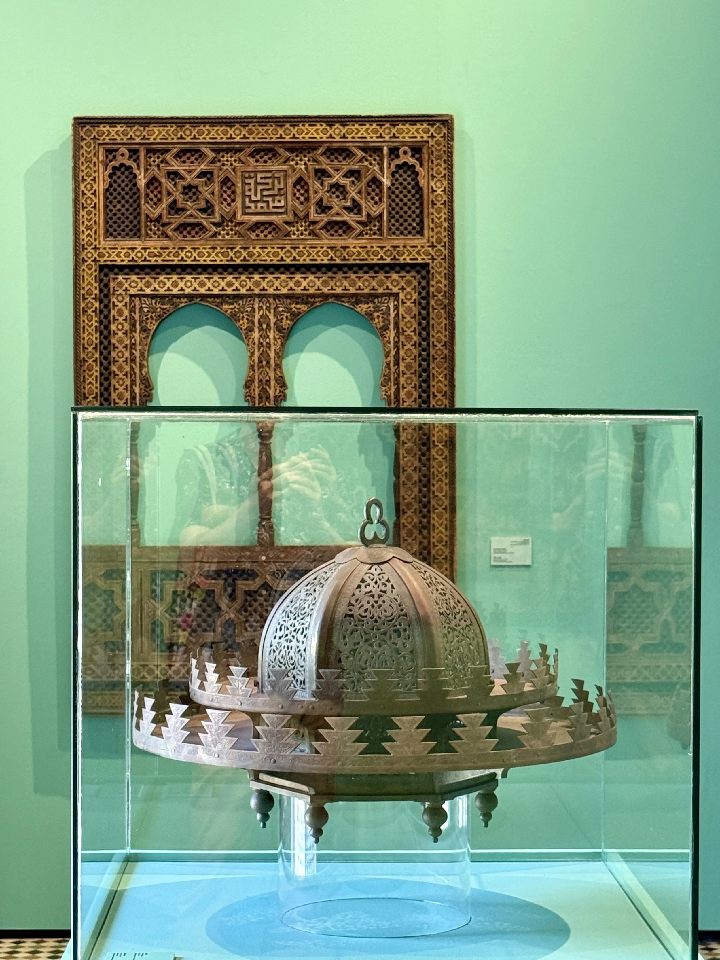 A bronze light feature with cedar window frames on display at Dar el Bacha in Marrakech, Morocco