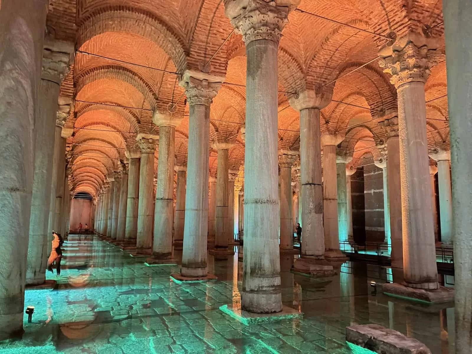 Columns, arches and turquoise-lit water in the Basilica Cistern in Istanbul