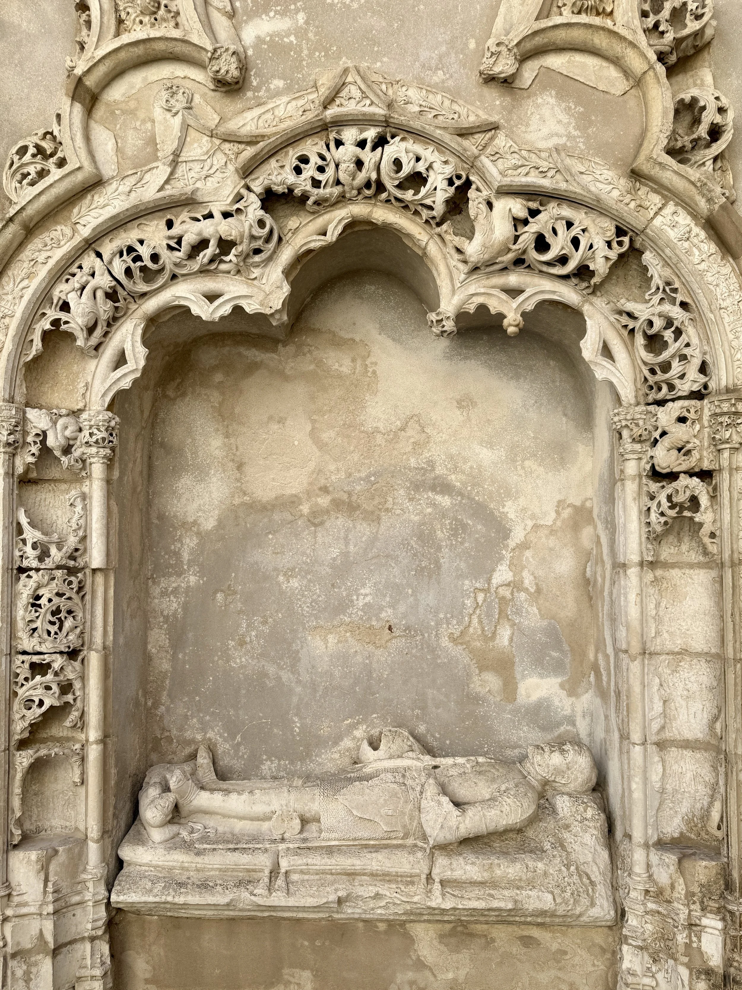 The limestone effigy of the knight Mem de Cerveira lies in repose beneath the delicate tracery of a Manueline arch at Carmo in Lisbon