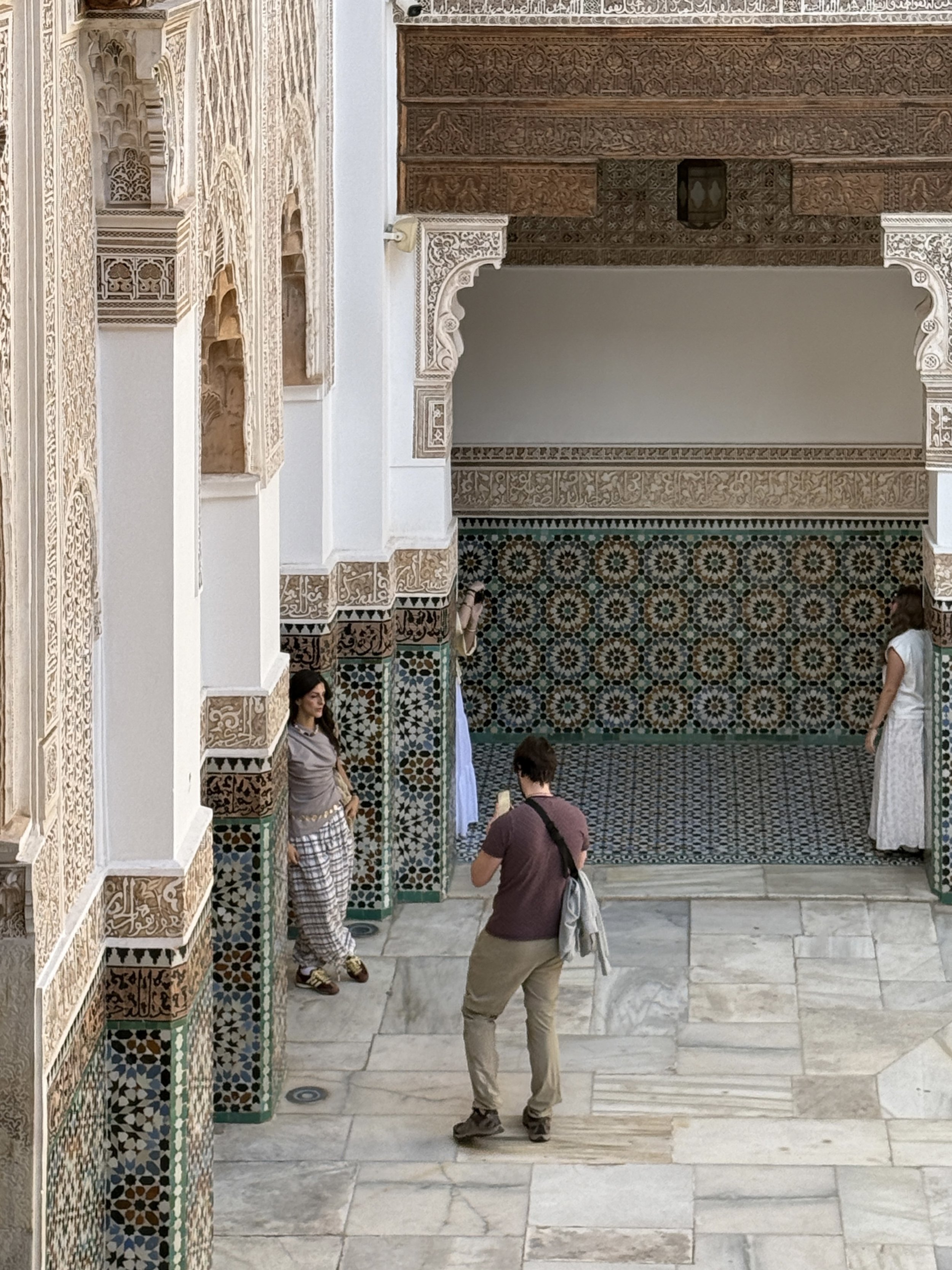 Women run through a series of poses to capture that perfect social media shot at Ben Youssef Madrasa's courtyard