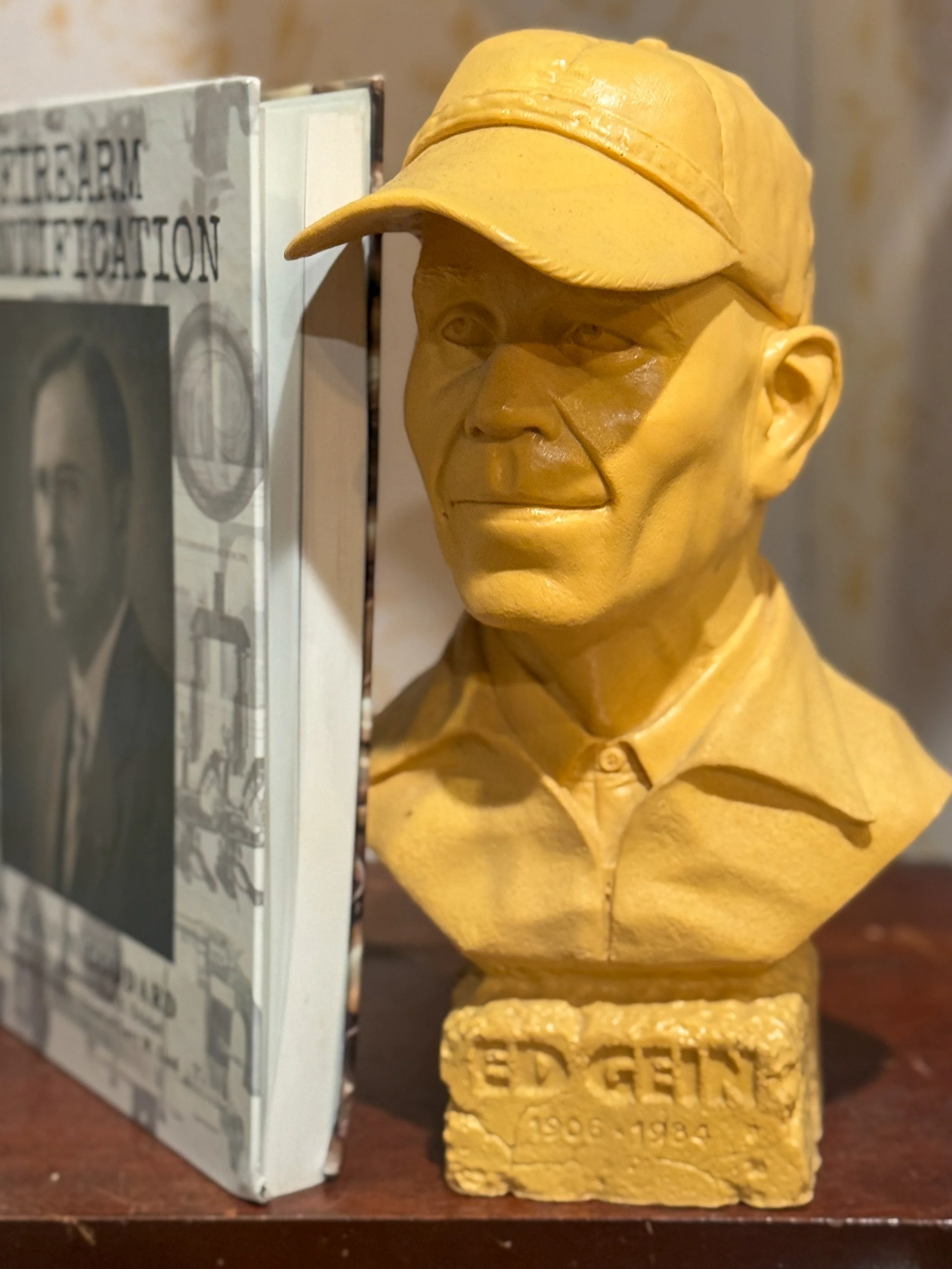 Book and yellow bust of Ed Gein, serial killer