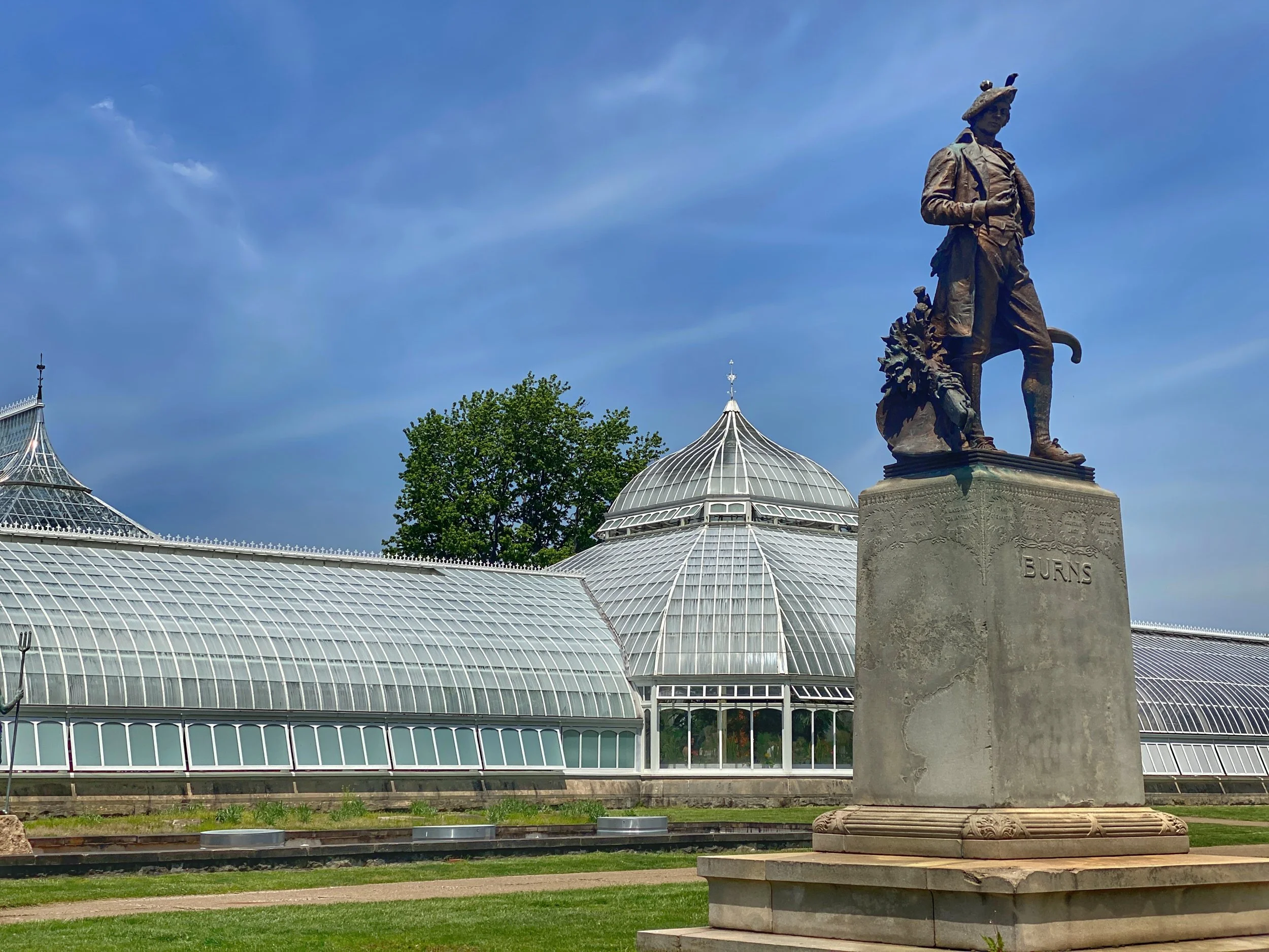 Statue of Burns in tam o' shanter in front of the Victorian glass-covered Phipps Conservatory and Botanical Gardens in Pittsburgh