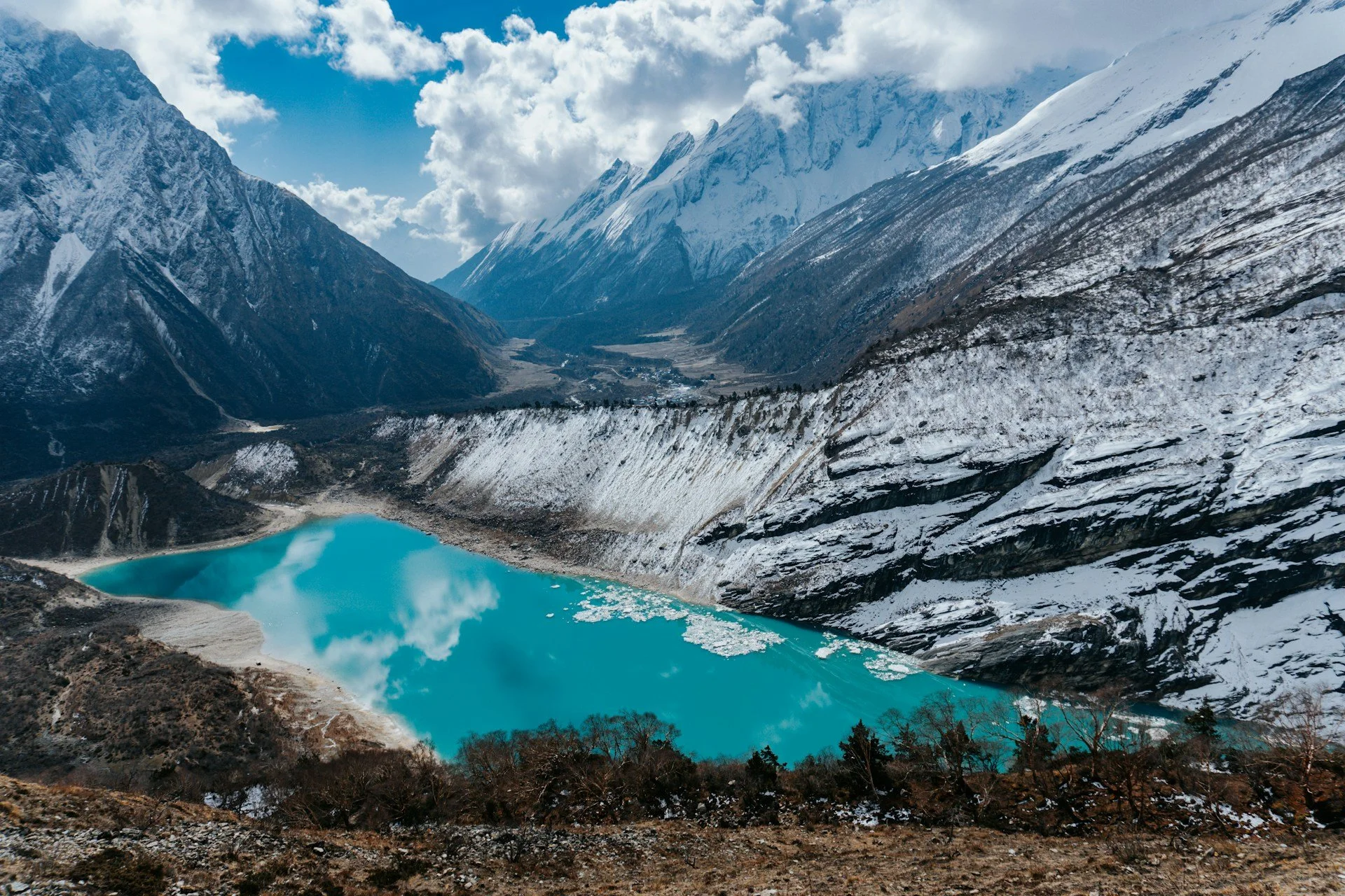 An aqua-colored lake in the snowy mountains of the Manaslu Circuit trek in Nepal