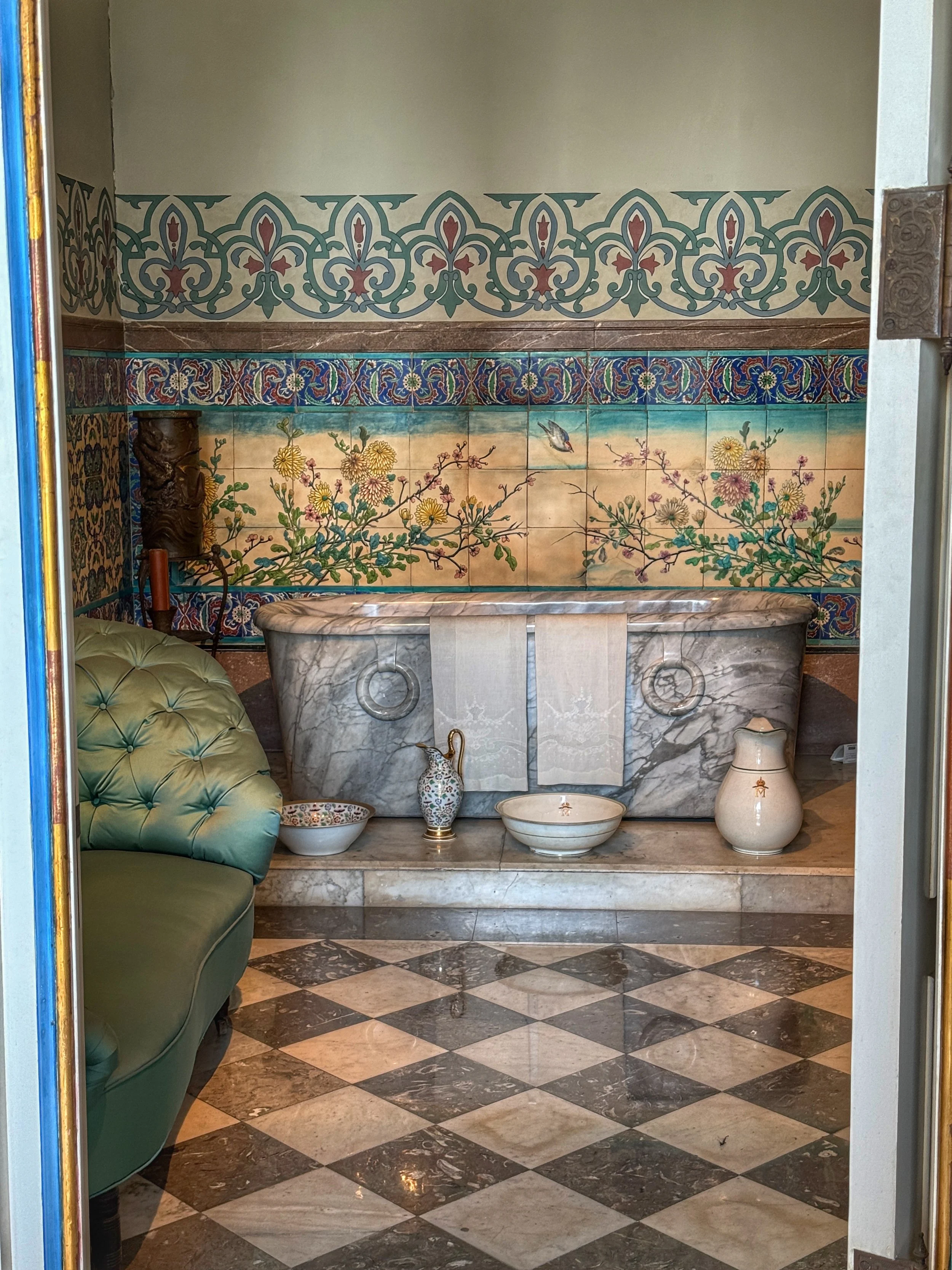 A marble bathtub and floral tiles in Charlotte's bathroom at Chapultepec Castle