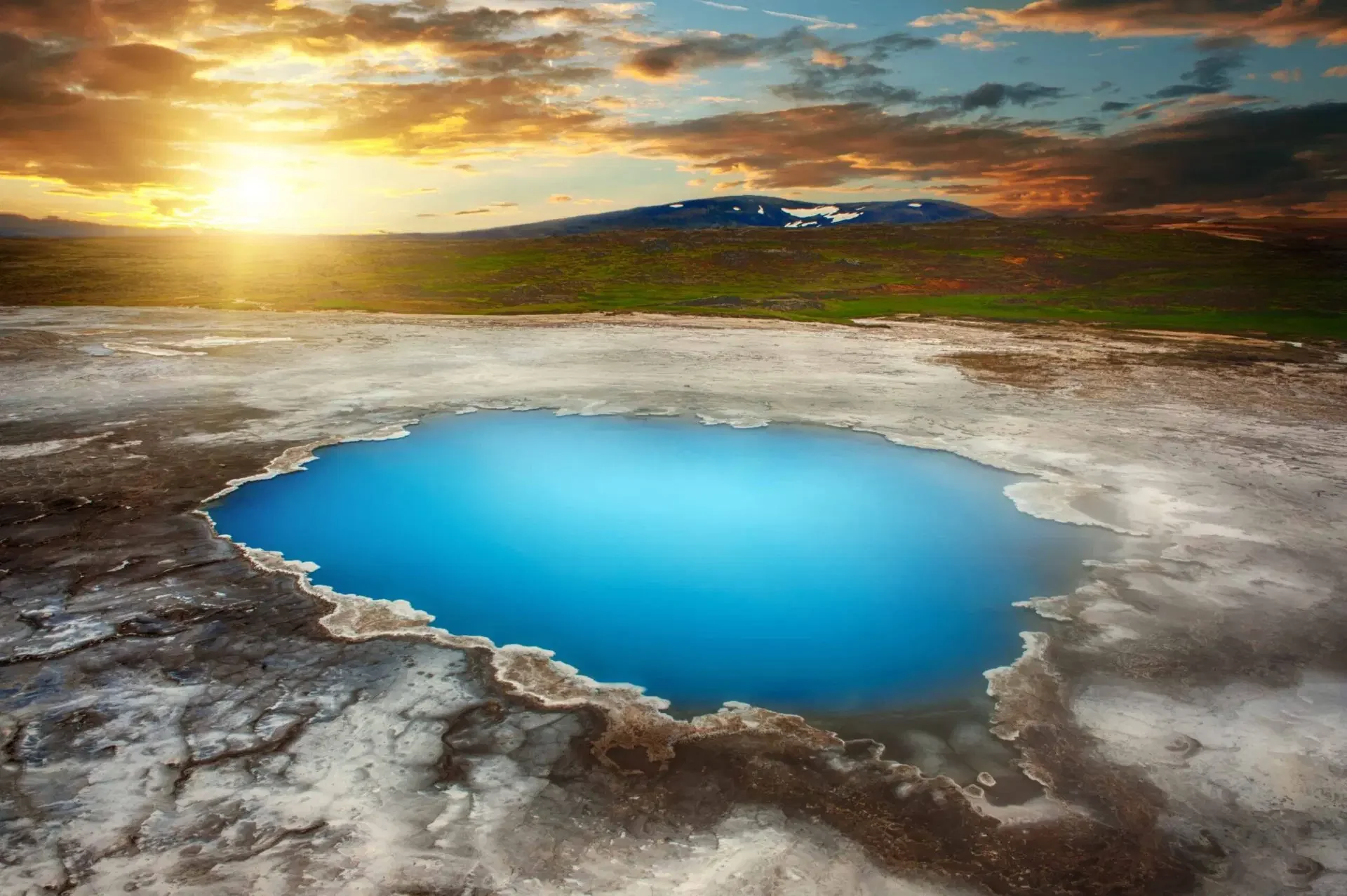 A bright blue pool amid a snowy landscape in Hveravellir, Iceland