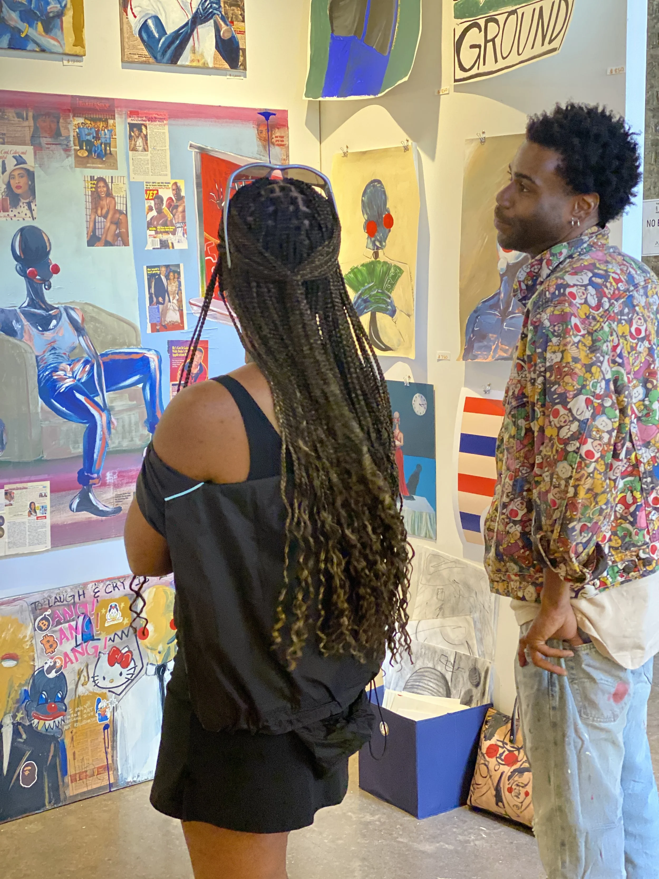 Two people look at paintings at the Other Art Fair in Chicago