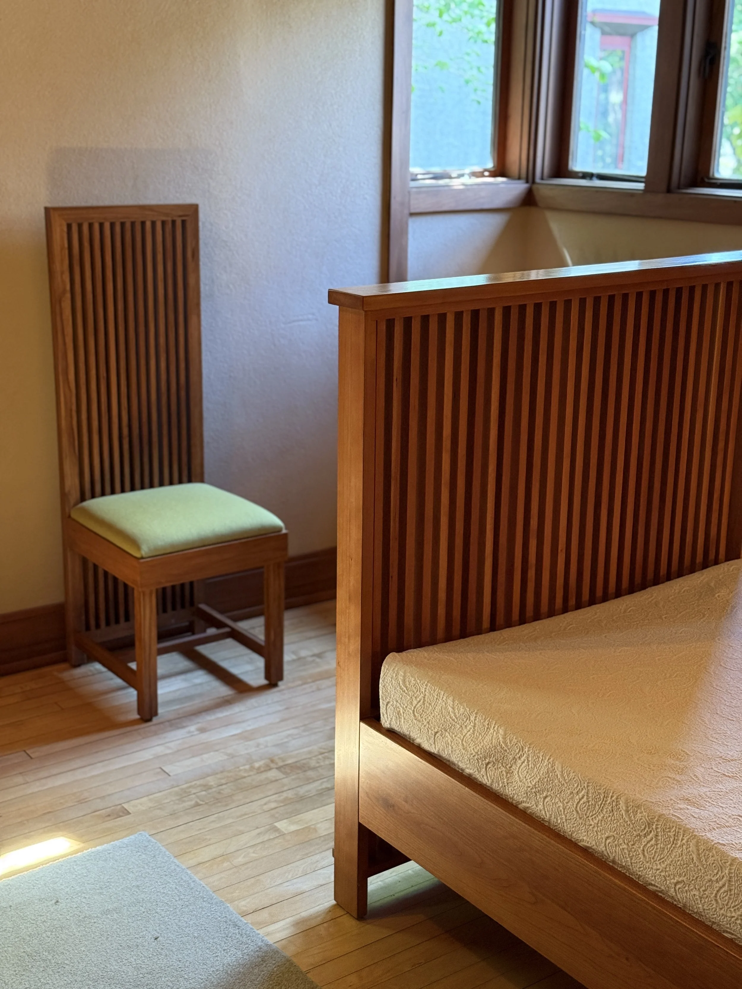 The foot of the bed and a chair in a bedroom of Model B1 at Frank Lloyd Wright's Burnham Block