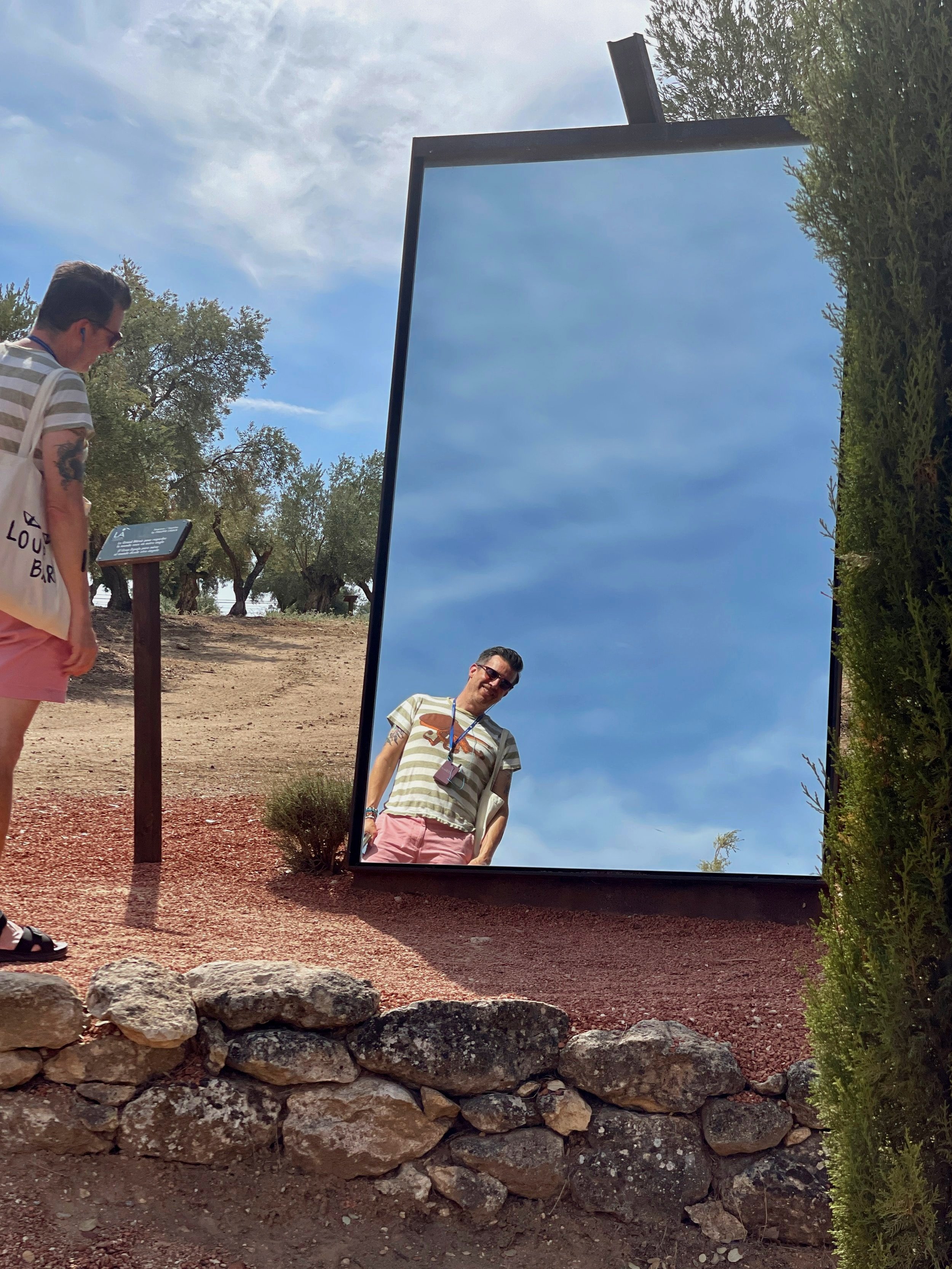 Man looks in a large mirror in the groves of LA Organic