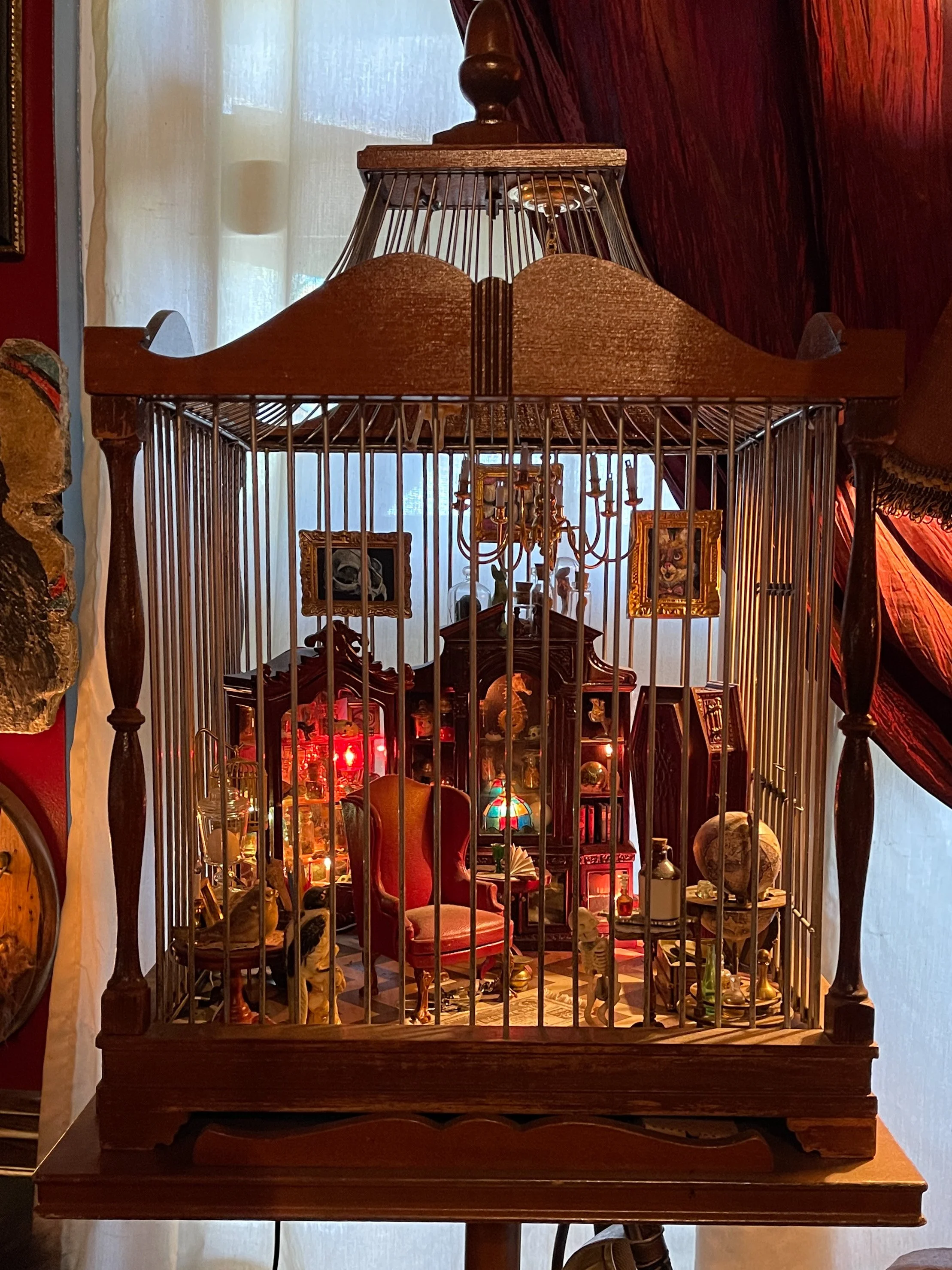Birdcage filled with miniature furniture, paintings, etc. at Trundle Manor