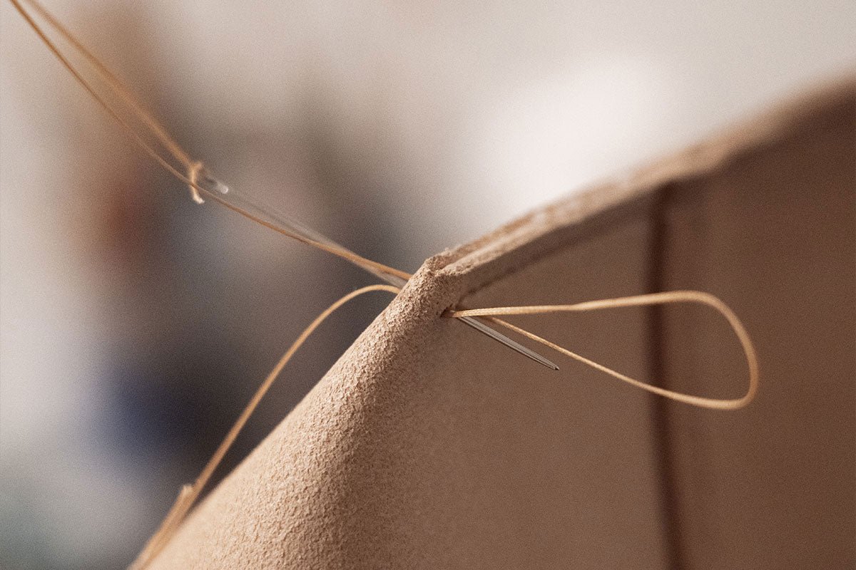 A closeup of a leather product from Atelier Madre being sewn
