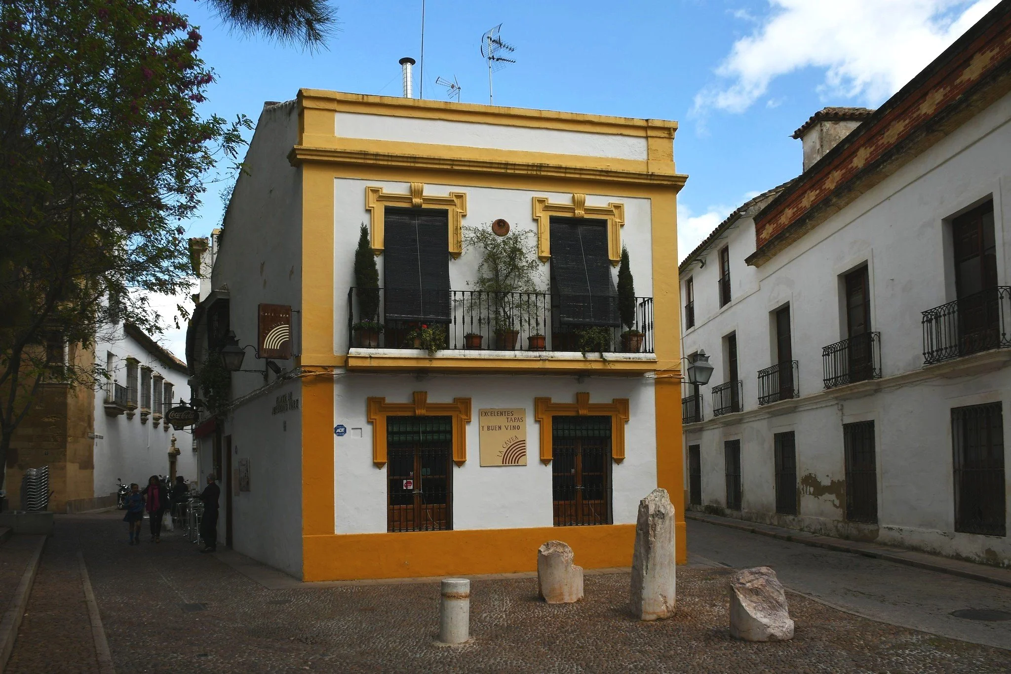Saffron-framed white cafe La Cavea in Cordoba