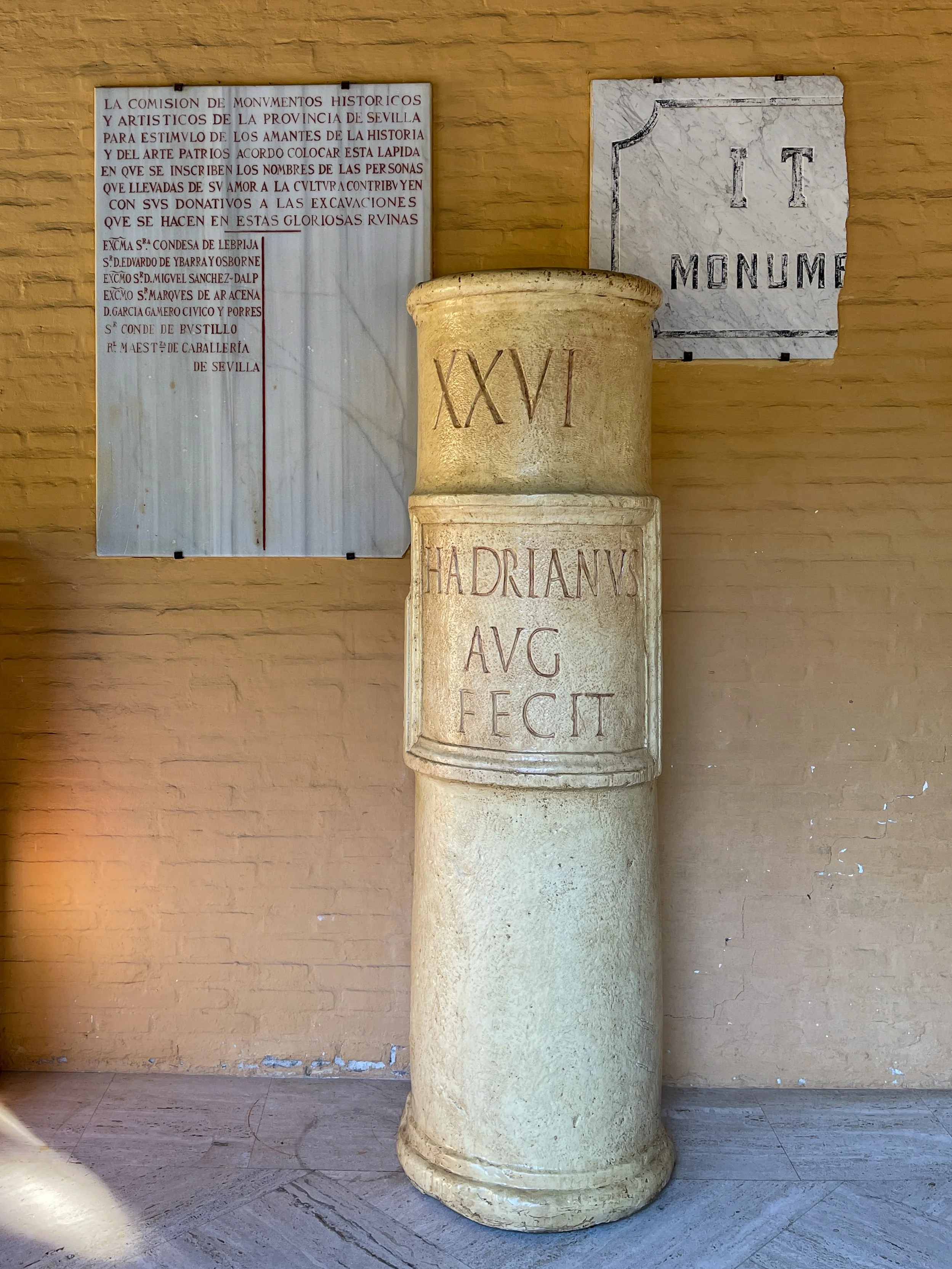 Historic plaques and a column bearing the emperor Hadrian's name at the Roman ruins of Italica in Spain