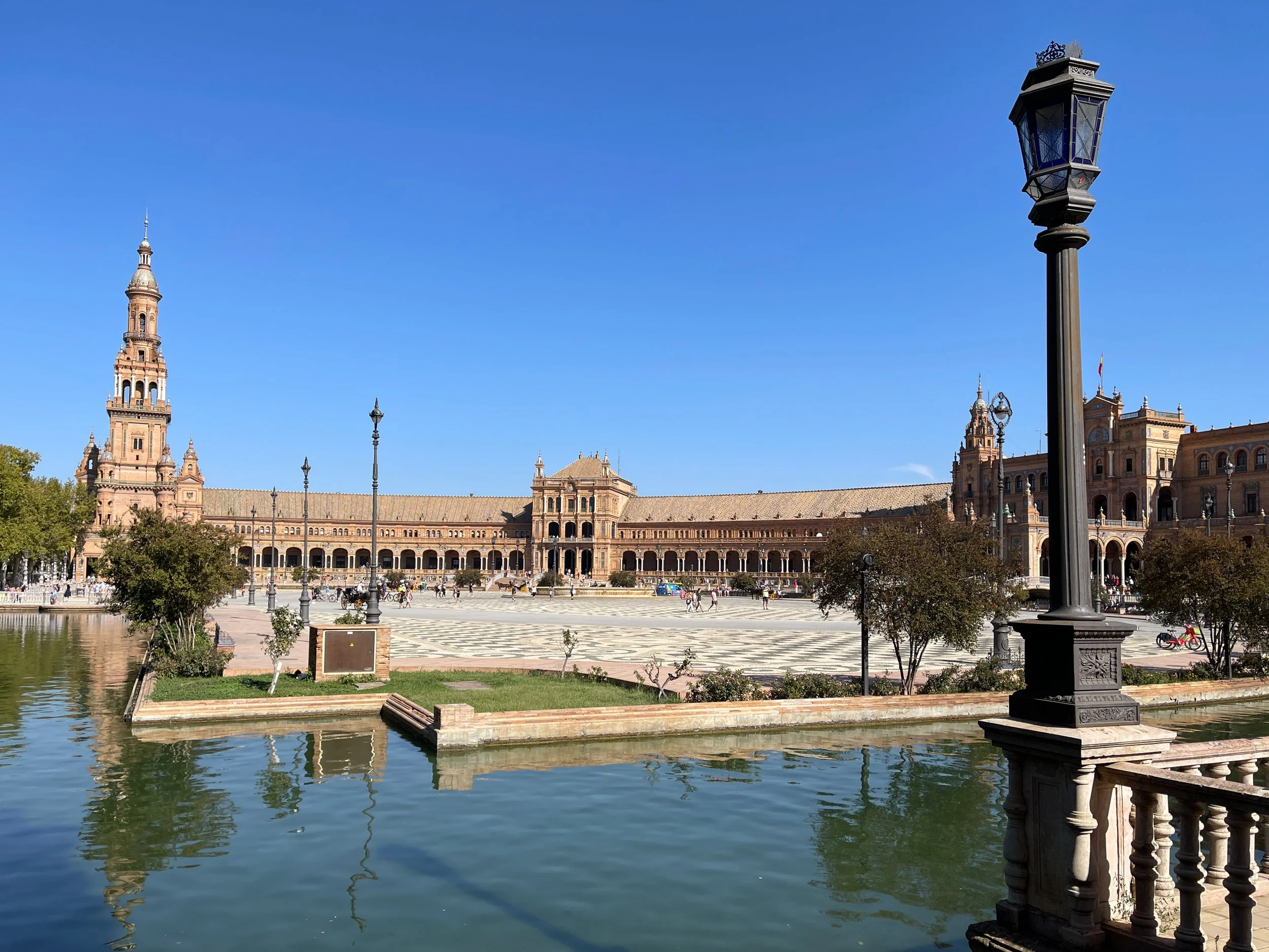 Curving building of the Plaza de España in Seville, with the moat and a lamppost
