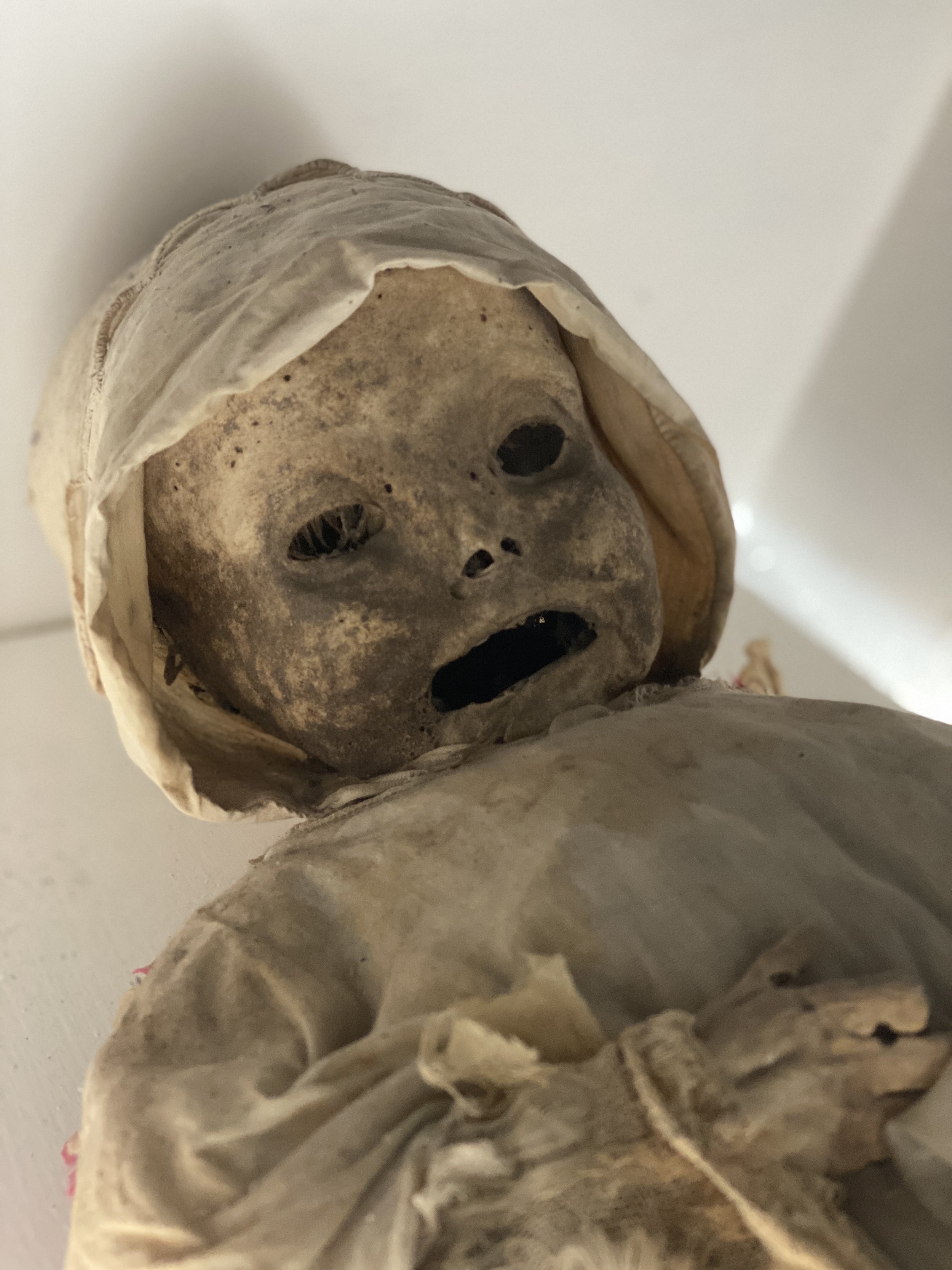 Mummy of baby in cap and dress at the Mummy Museum of Guanajuato