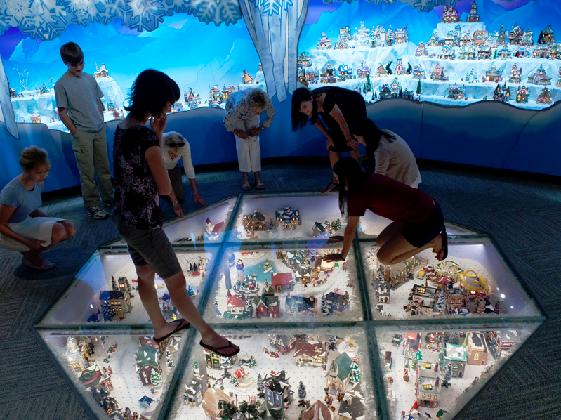 Kids look down at a miniature scene in an octagon on the floor at the Mini Time Machine Museum of Miniatures in Arizona