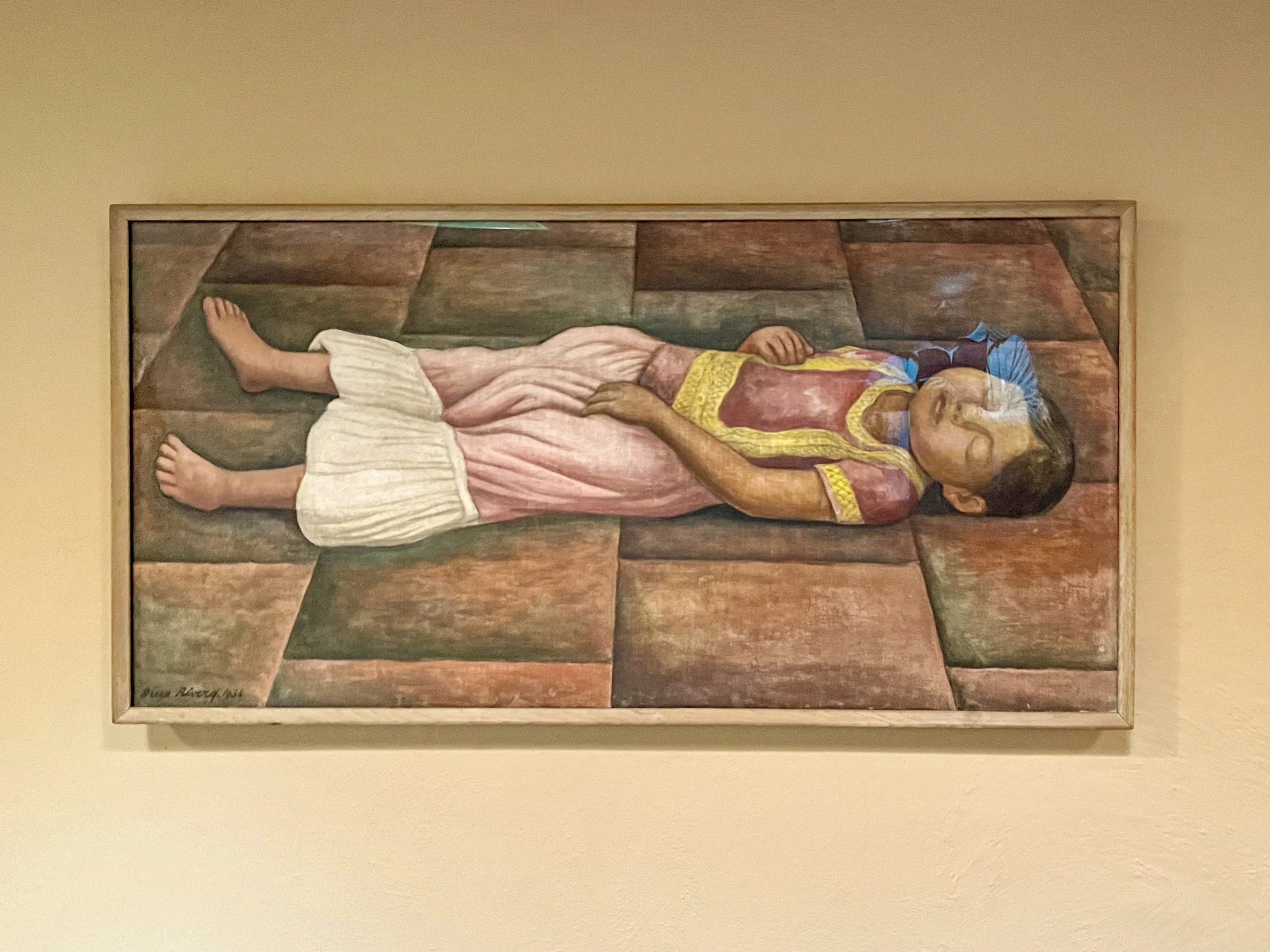 Torrid Siesta (El Sueño) by Diego RIvera, of a young girl laying on the ground, hanging at Fallingwater