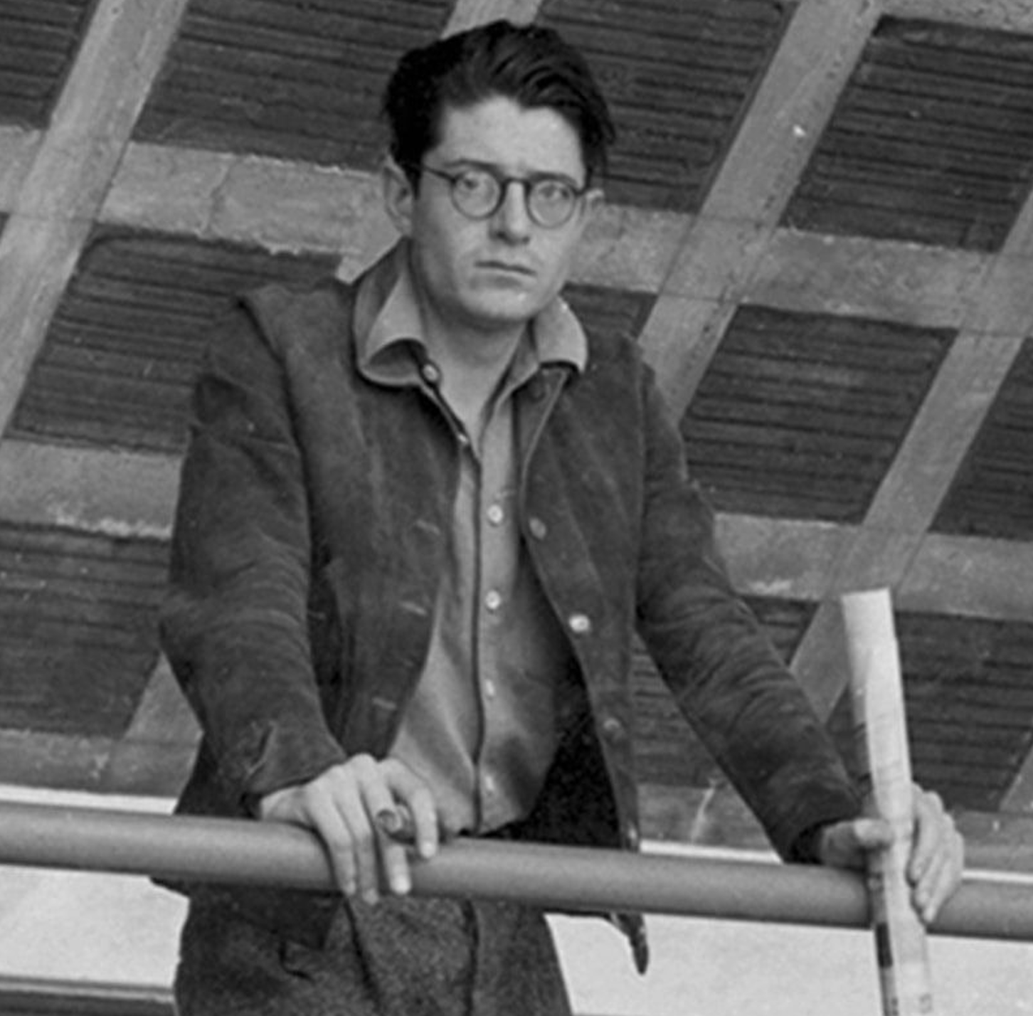The Mexican artist Juan O'Gorman, wearing glasses and holding a cigar, leans on a railing