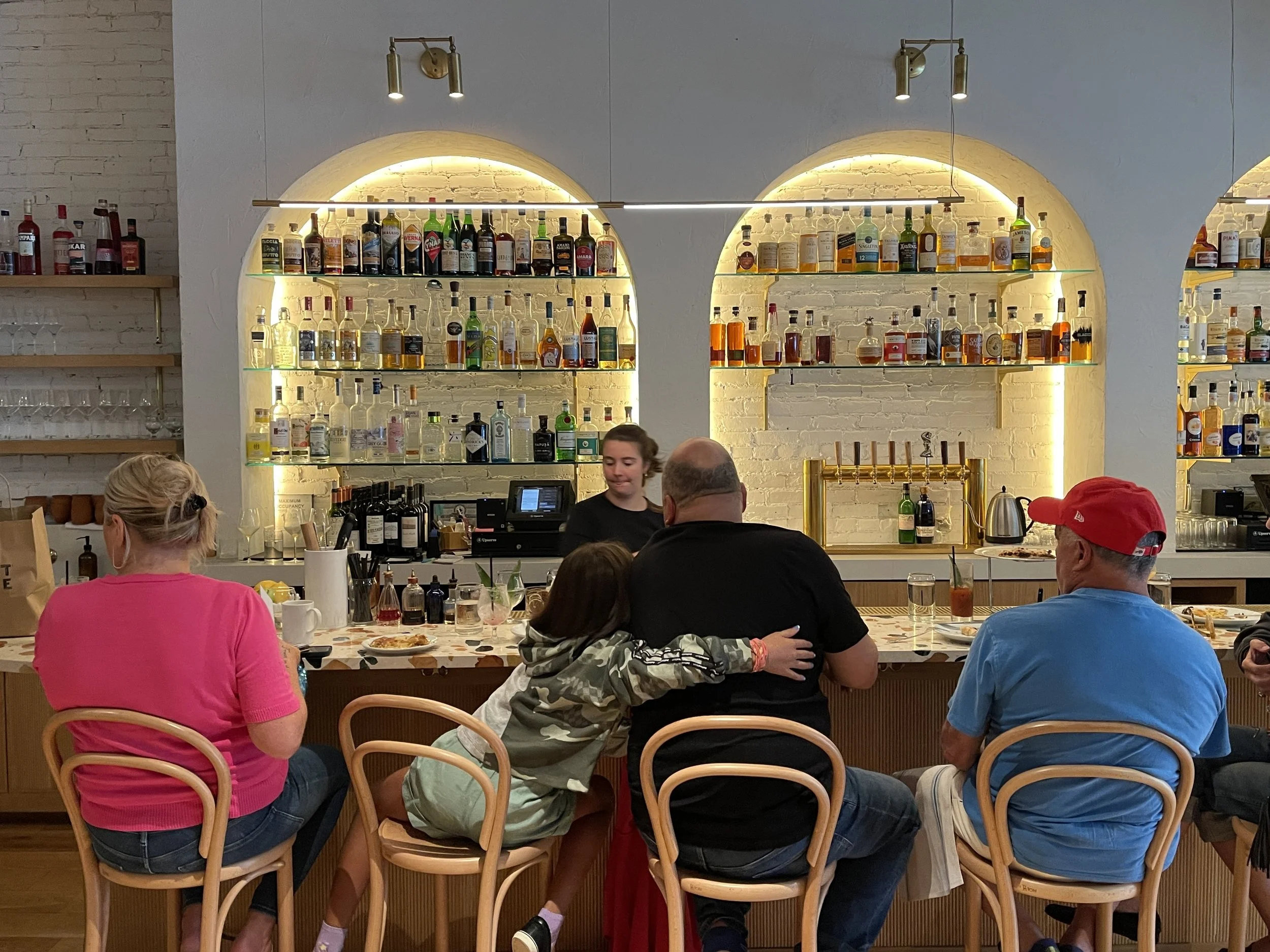 People at the bar at West Rose in Eville, New York, including girl hugging man