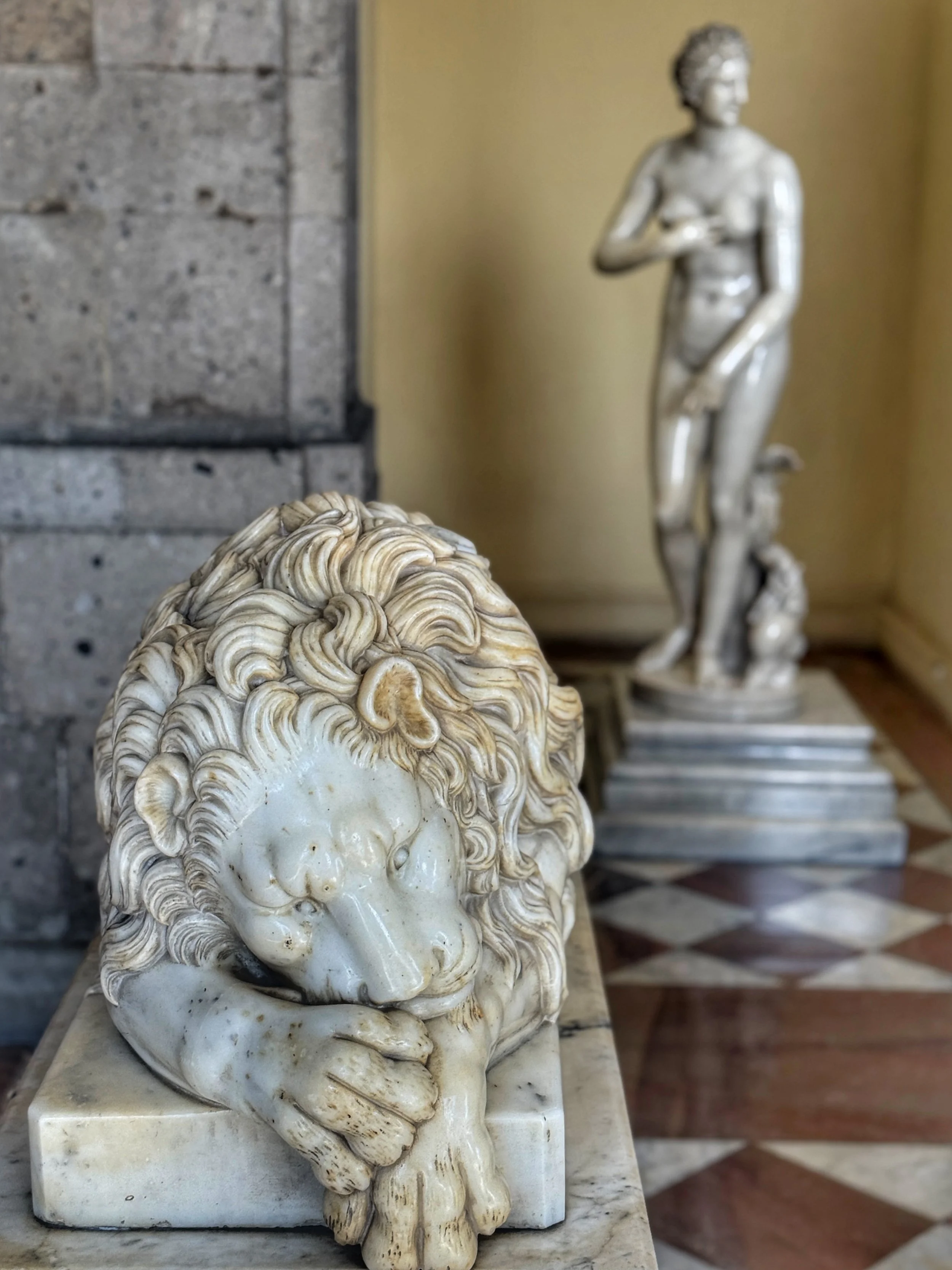Marble lion with a statue of a naked woman behind it by a staircase in Chapultepec Castle