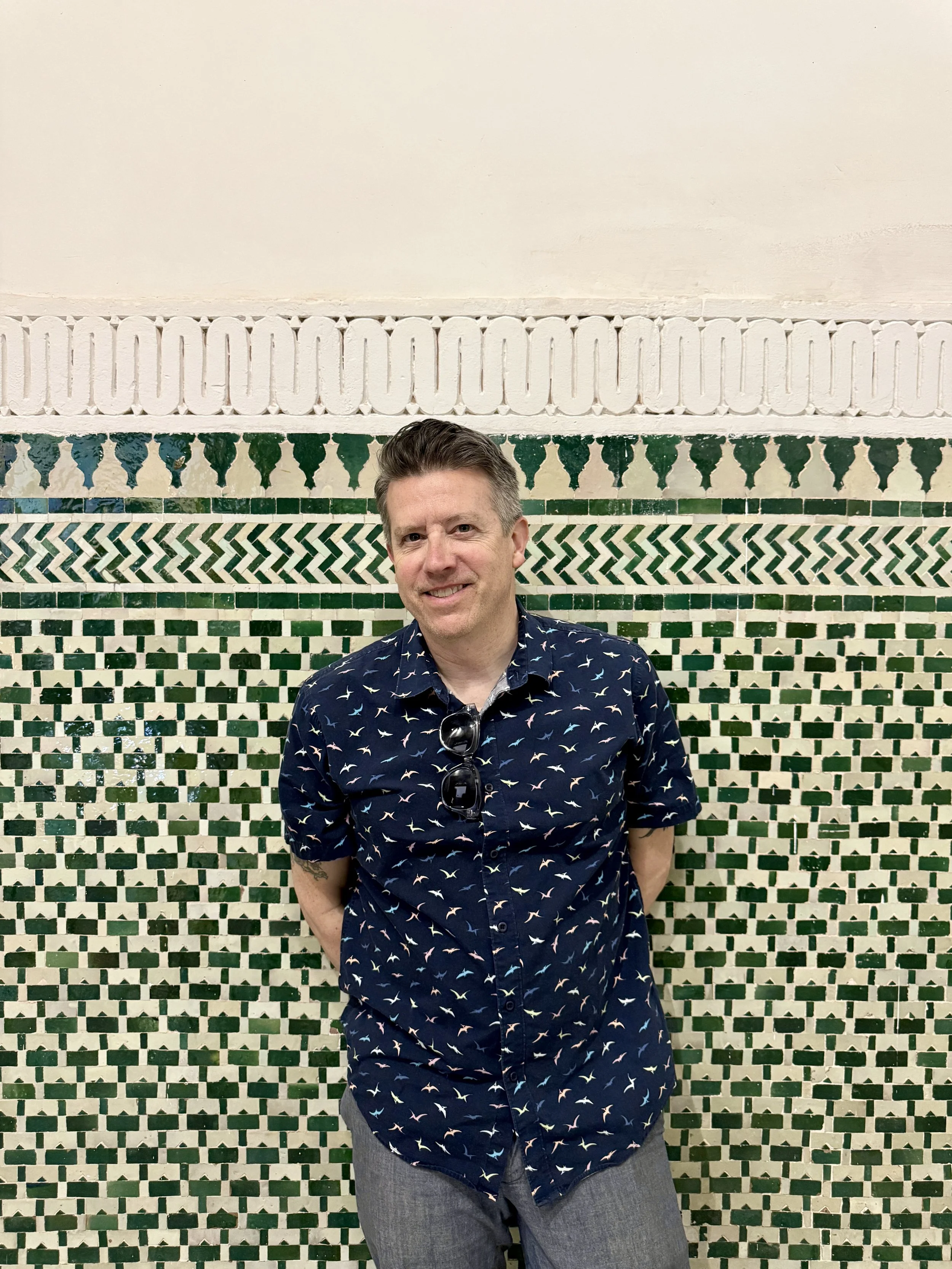 Wally leaning against a tiled wall in the vestibule of Dar el Bacha, Marrakech, Morocco
