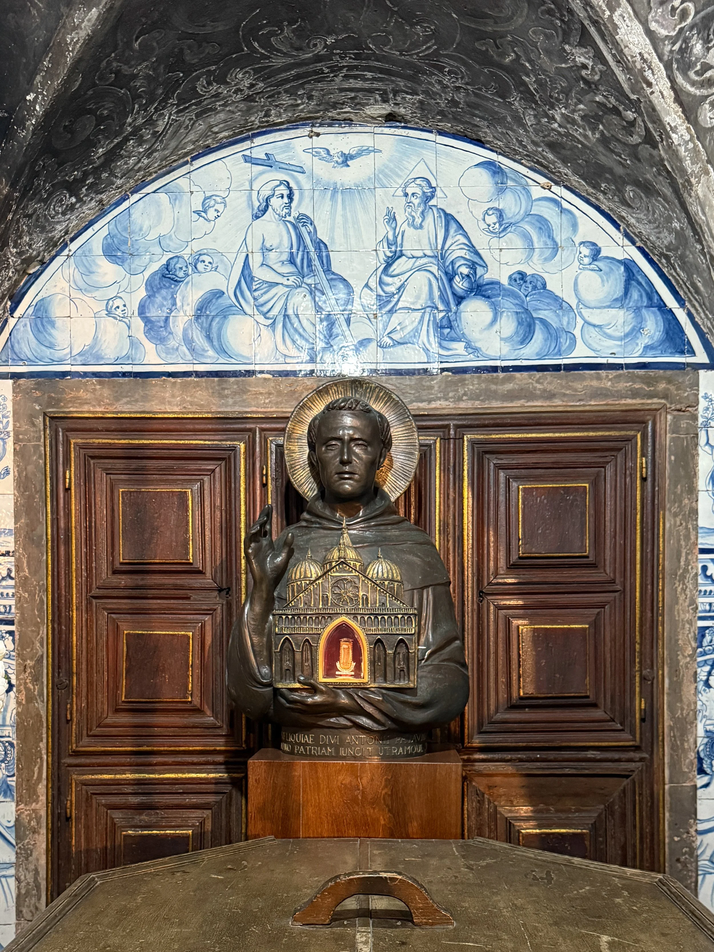 Near Lisbon Cathedral's entrance, surrounded by blue and white tile panels, stands the baptismal font where both Saint Anthony and Padre António Viera, a prominent 17th century Jesuit priest, were christened