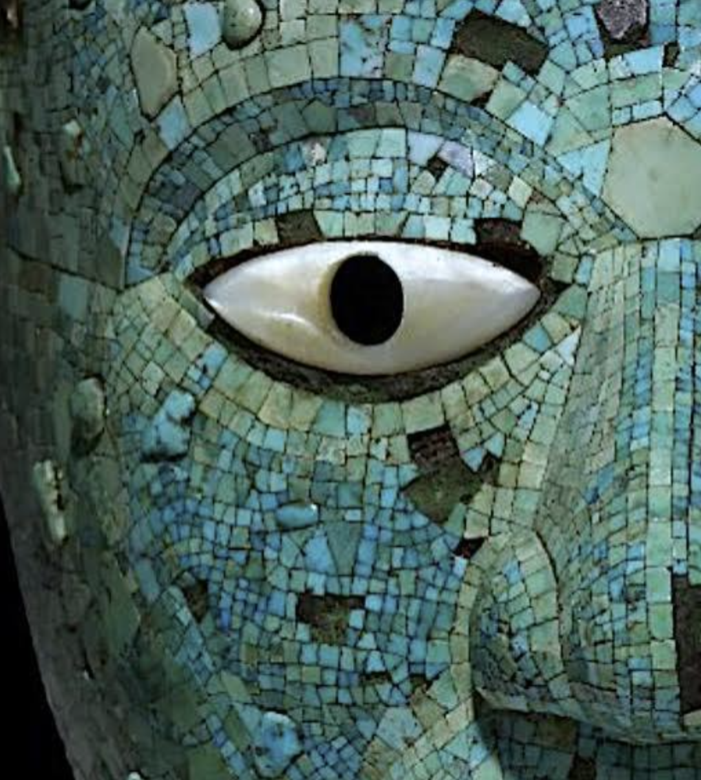 Detail of a Maya statue covered with turquoise, showing an eye and part of a face