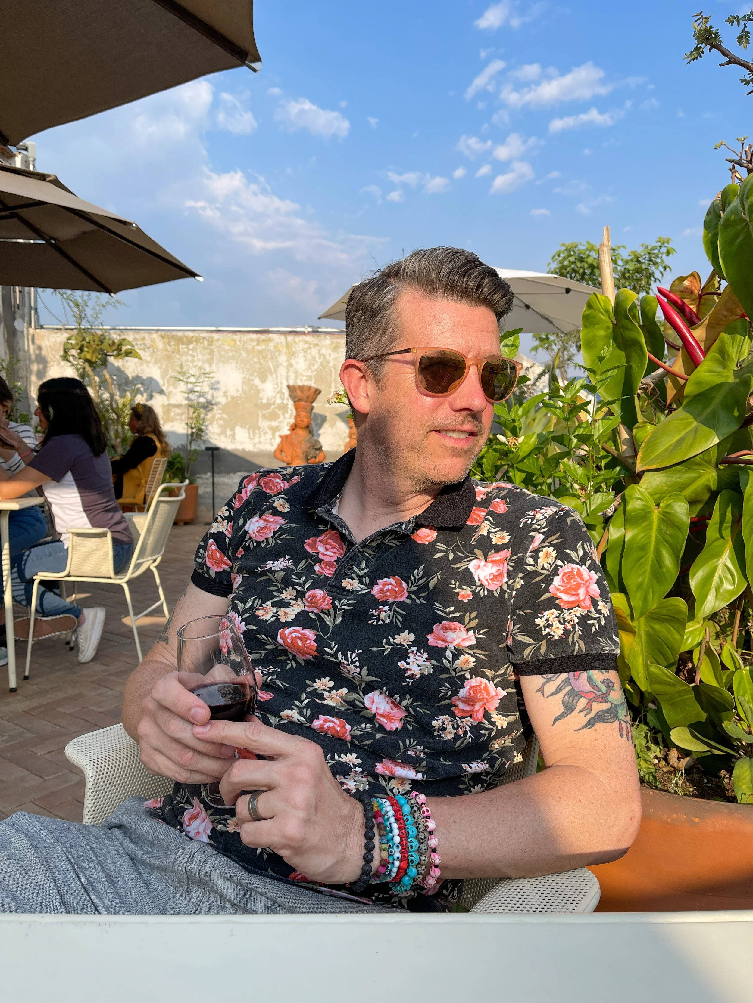 Man in floral shirt and sunglasses drinking wine on rooftop in Oaxaca