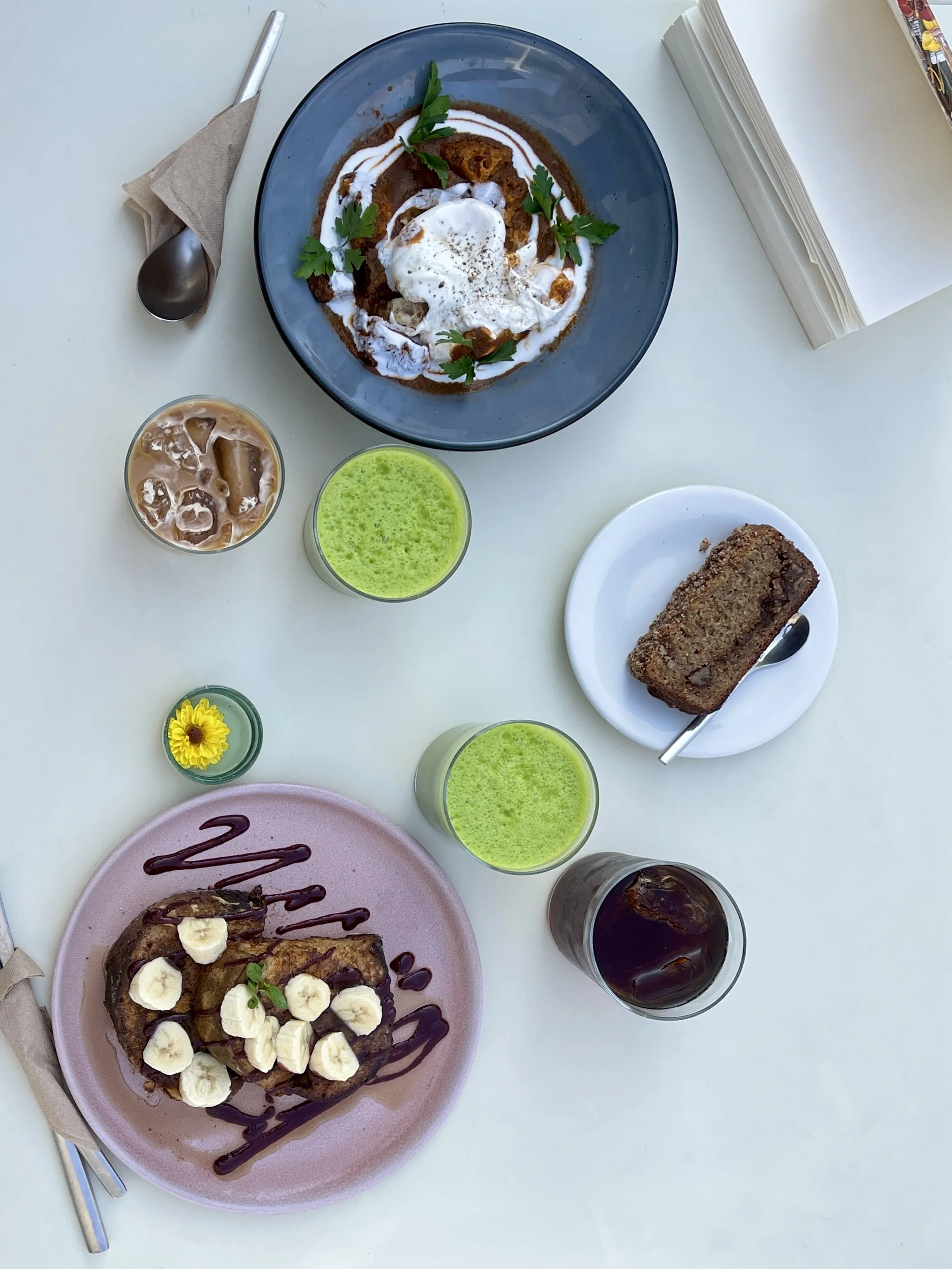 Top-down of breakfast with shakshouka and banana and chocolate French toast