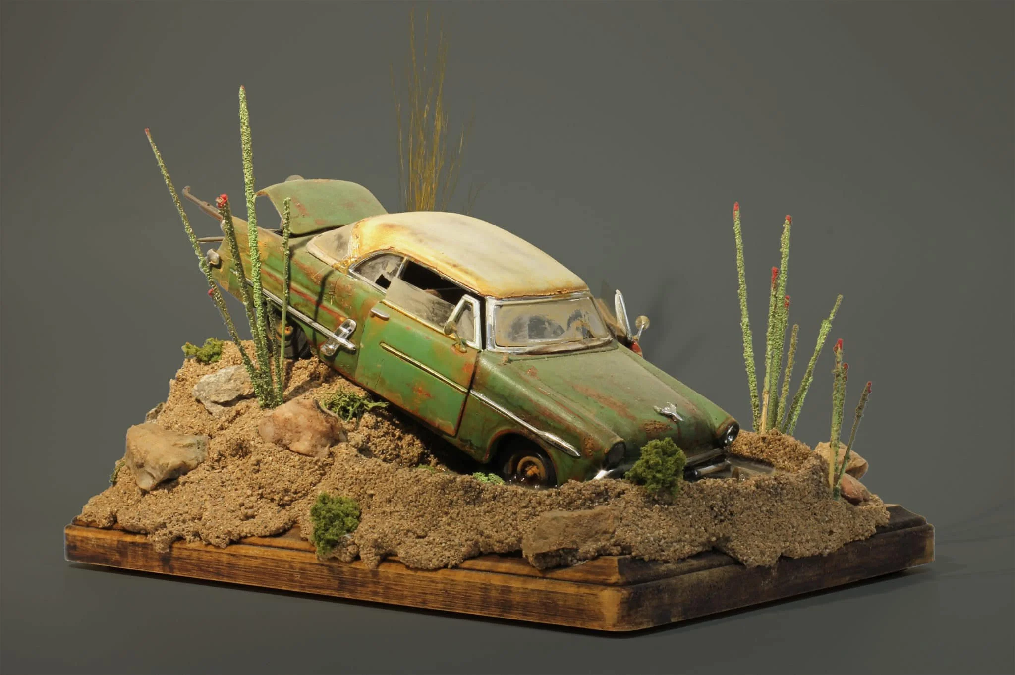 A model of a classic green car sunken in the water as part of Jim Roark's Metal Monsters exhibit at the Museum of Miniatures in Arizona