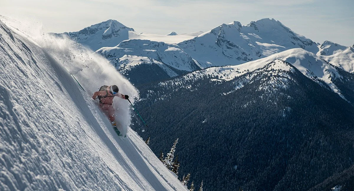 A person snowboards down a steep slope in Whistler, Canada