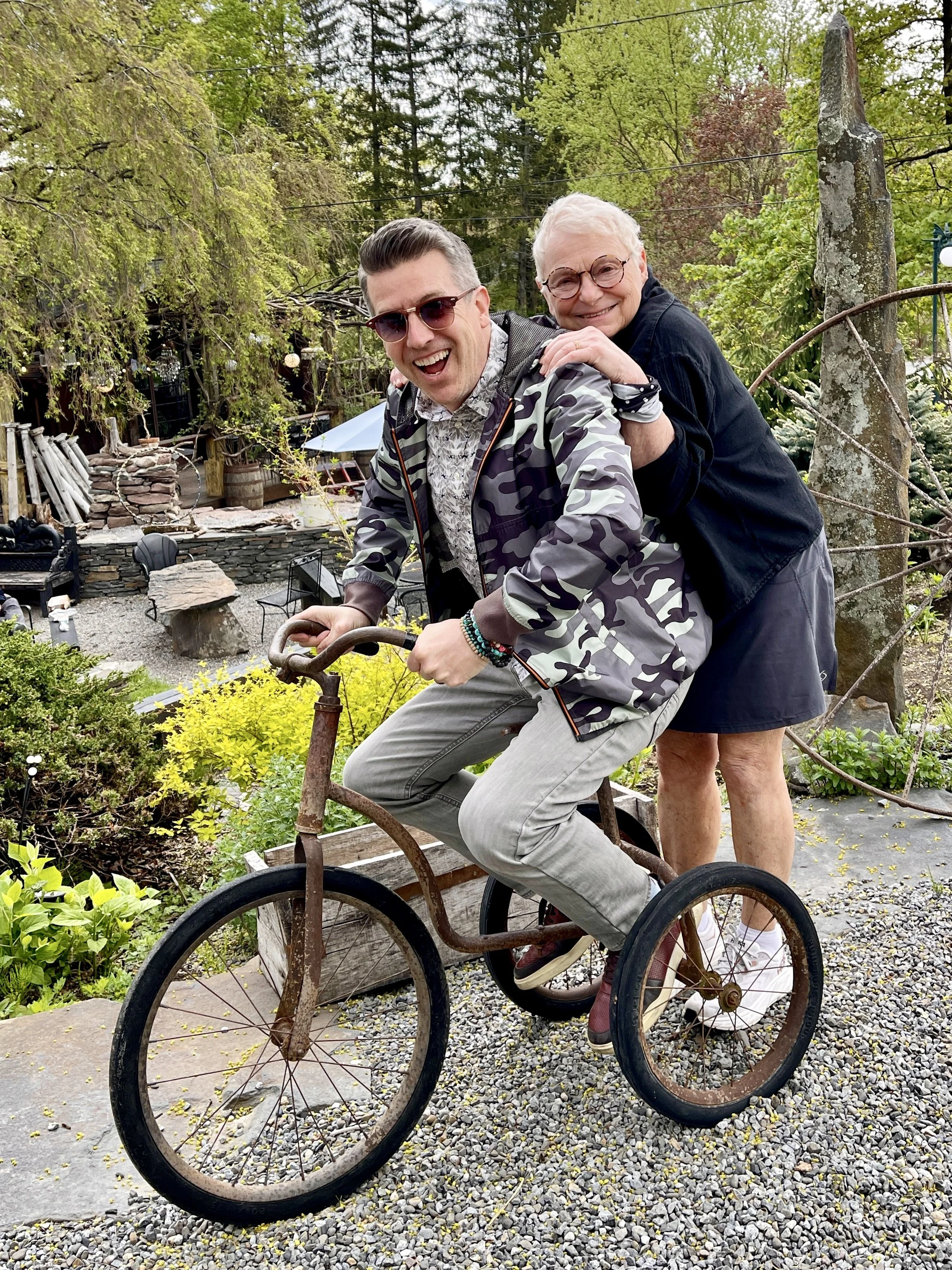 A man and woman ride a large trike at the Mud Club, Woodstock, NY