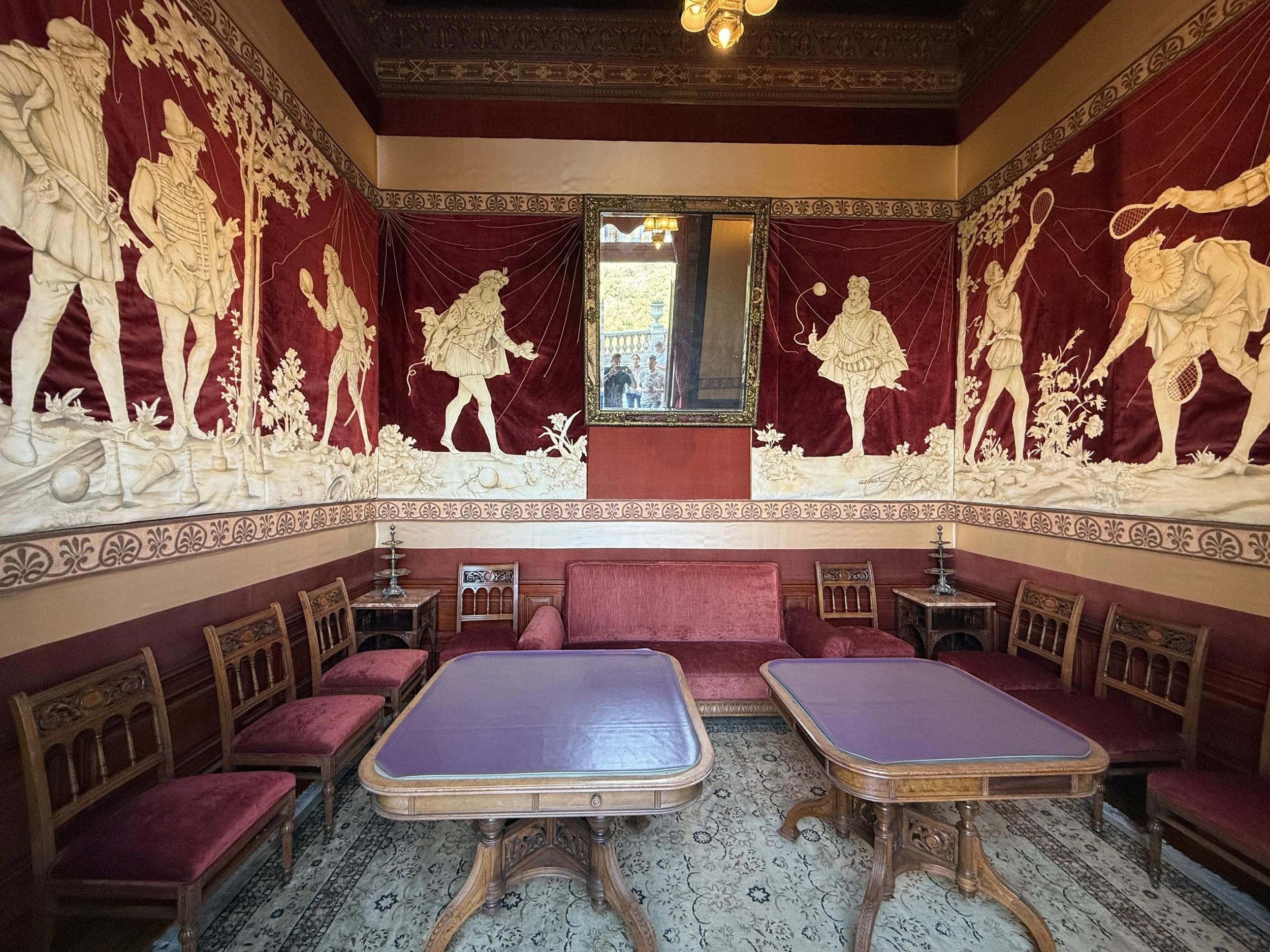 Burgundy and offwhite murals showing noblemen playing games in the Salón de Juego (Game Room) at Chapultepec Castle
