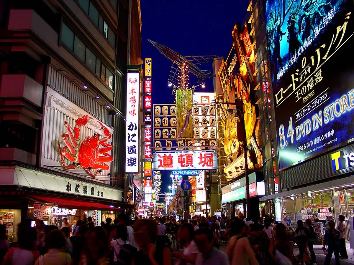 The crowded streets of the Dotonbori district in Osaka, Japan, with neon signs everywhere