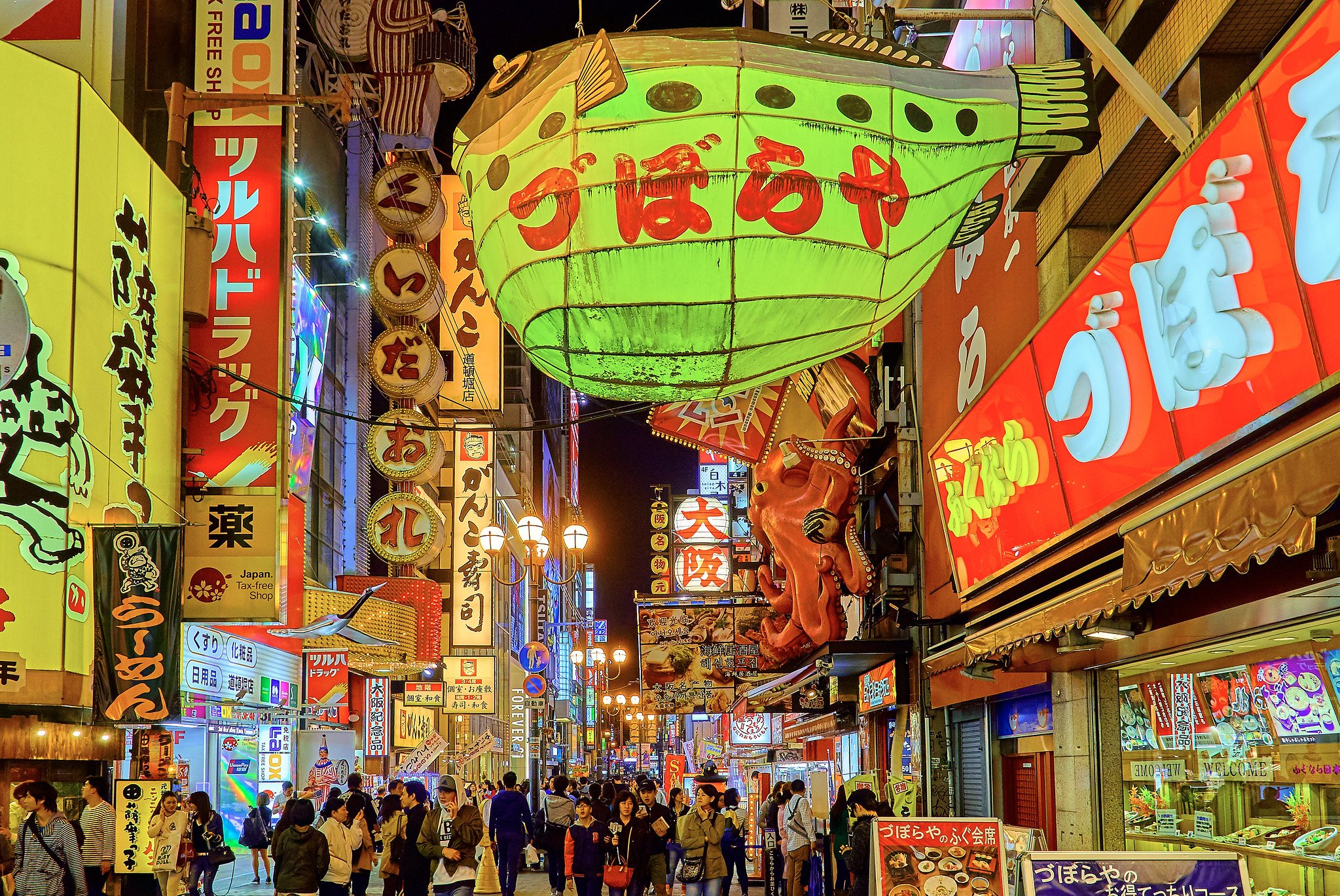 The historic Shinsekai district of Osaka, Japan at night, with a giant fish paper lantern and retro signs