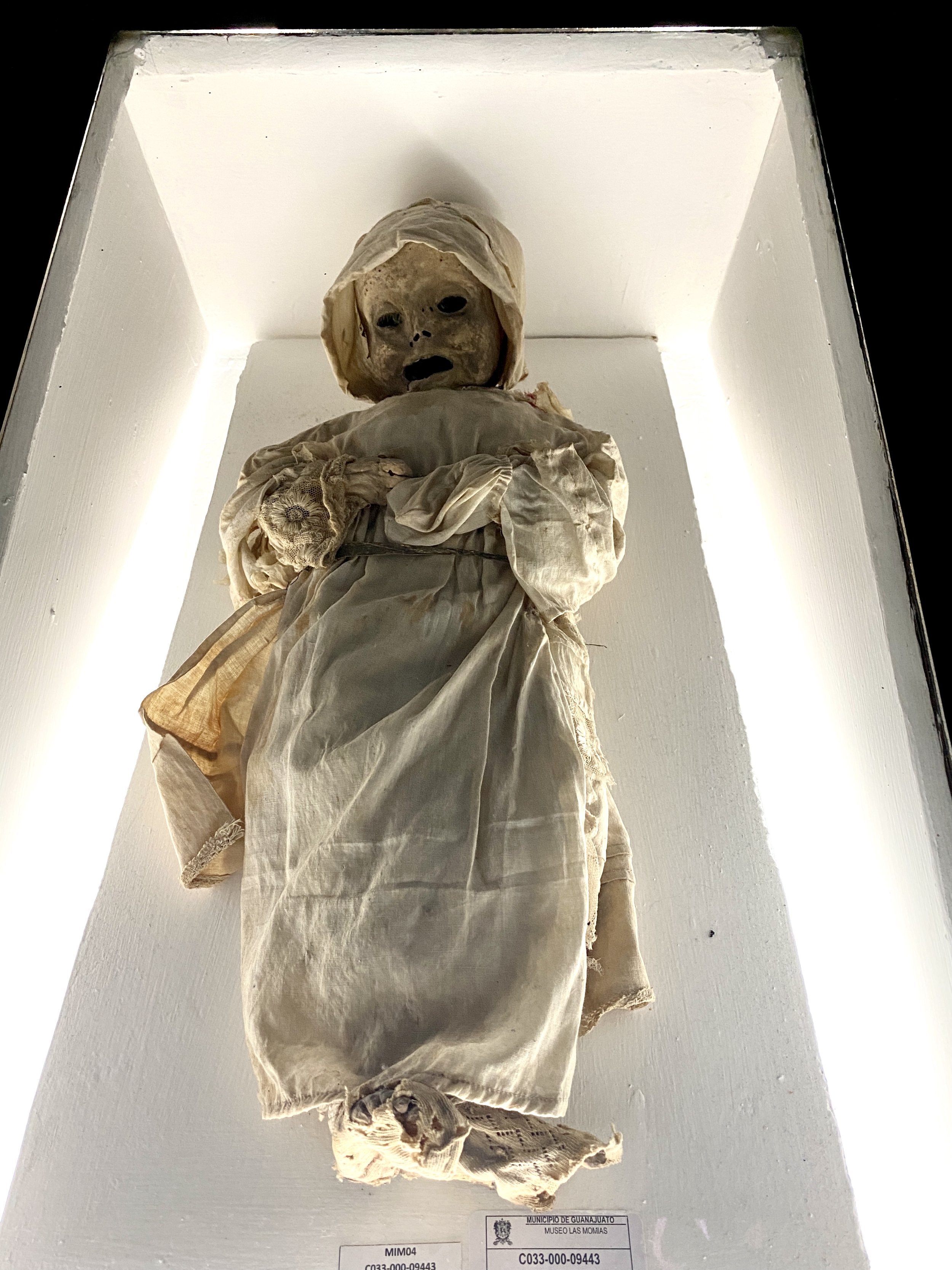 Mummy of baby in cap and dress at Museo de las Momias